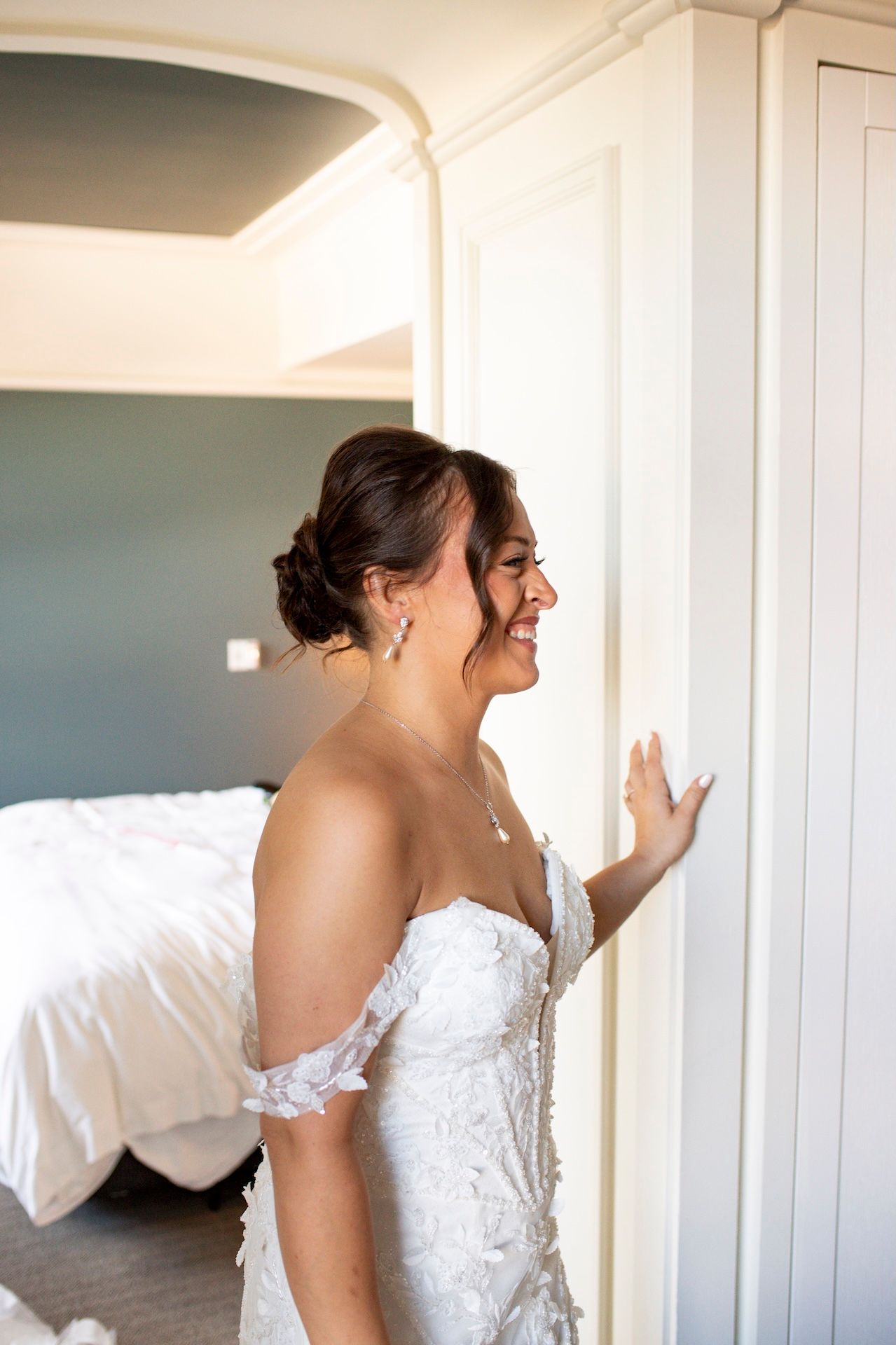 Sunlight streams through windows in an elegant white room during wedding preparations.
