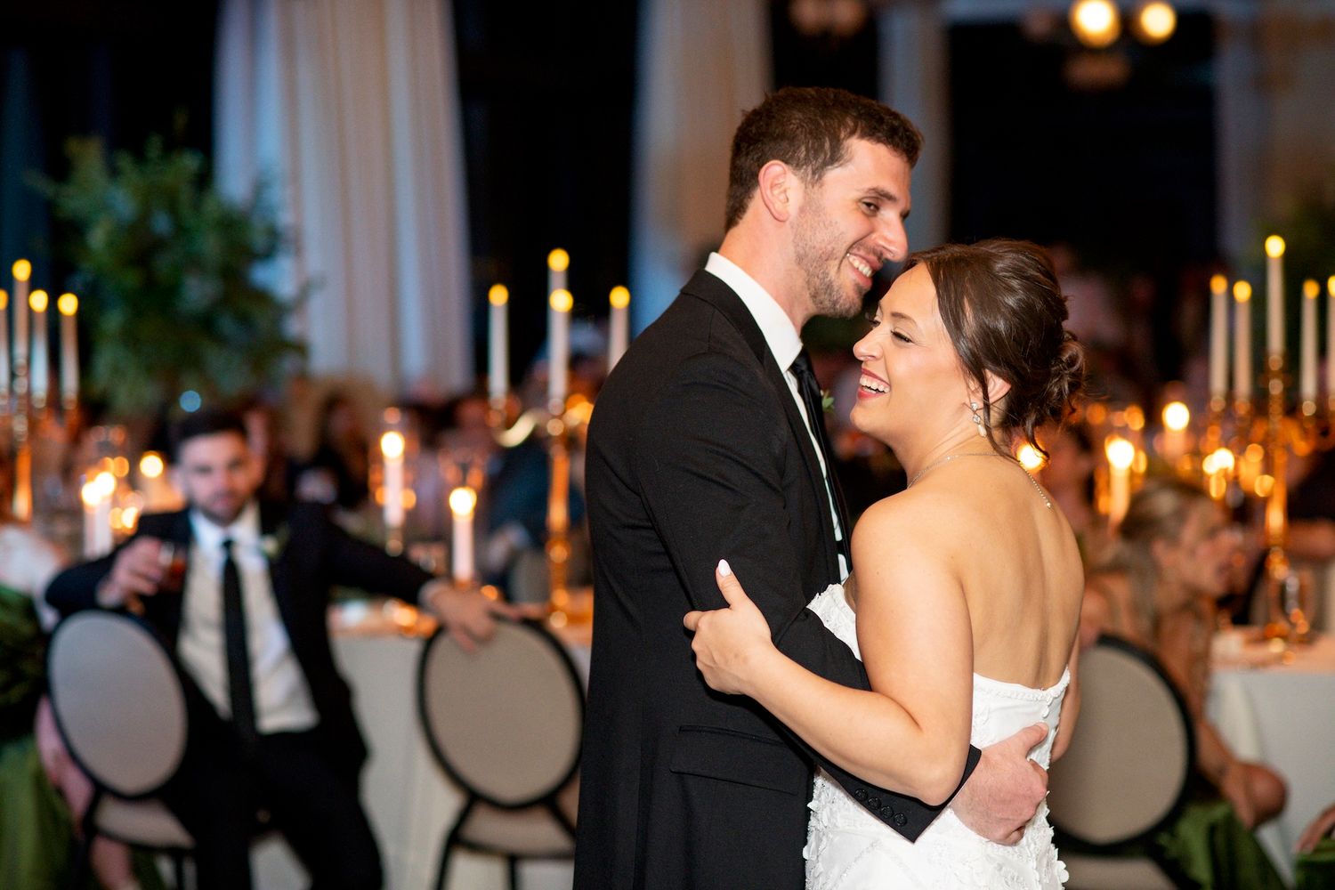 Couples dancing together at an elegant evening wedding reception with warm lighting and formal attire.