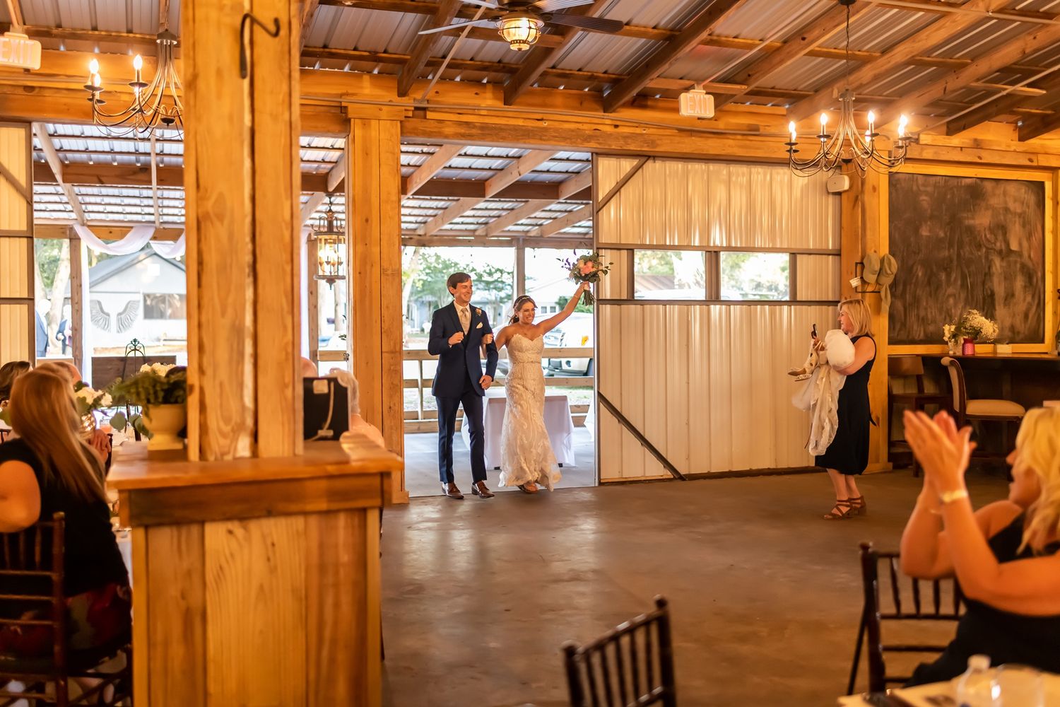 Rustic wooden barn interior with exposed beams and warm lighting showcases event space setup.