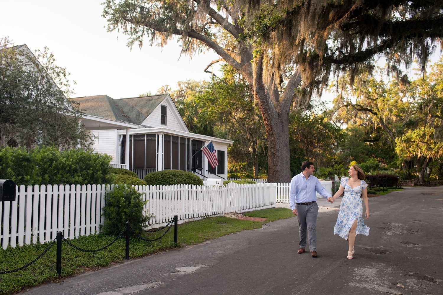 People walking down a tree-lined path at sunset with Spanish moss hanging from oak branches on the bluff in Isle of Hope
