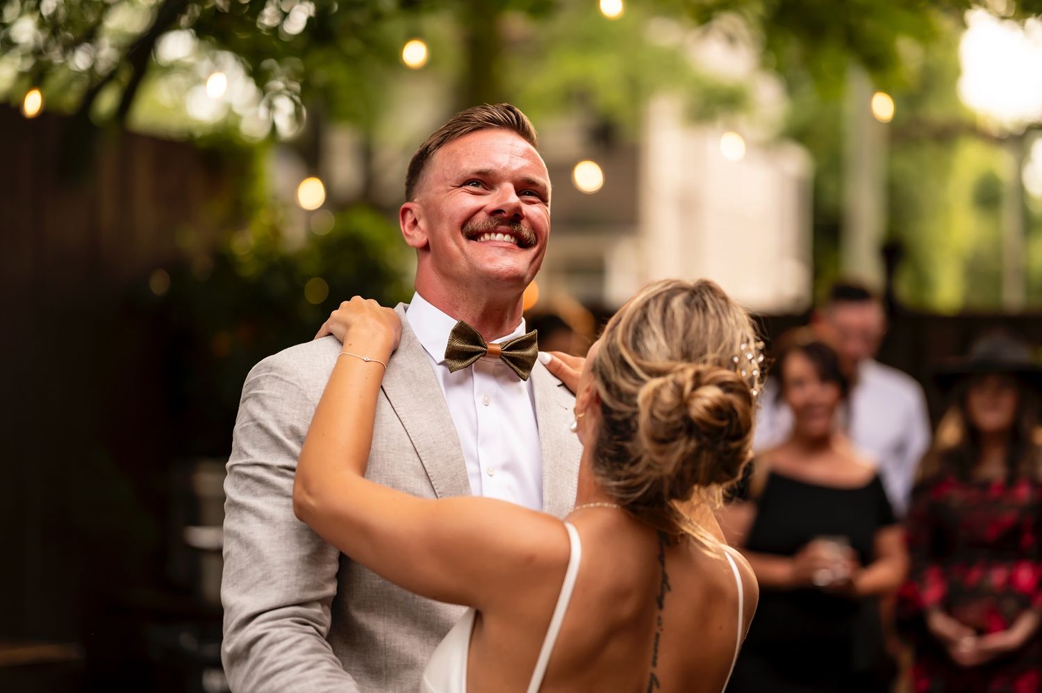 Happy newlyweds share a sweet first dance together at their outdoor wedding reception.