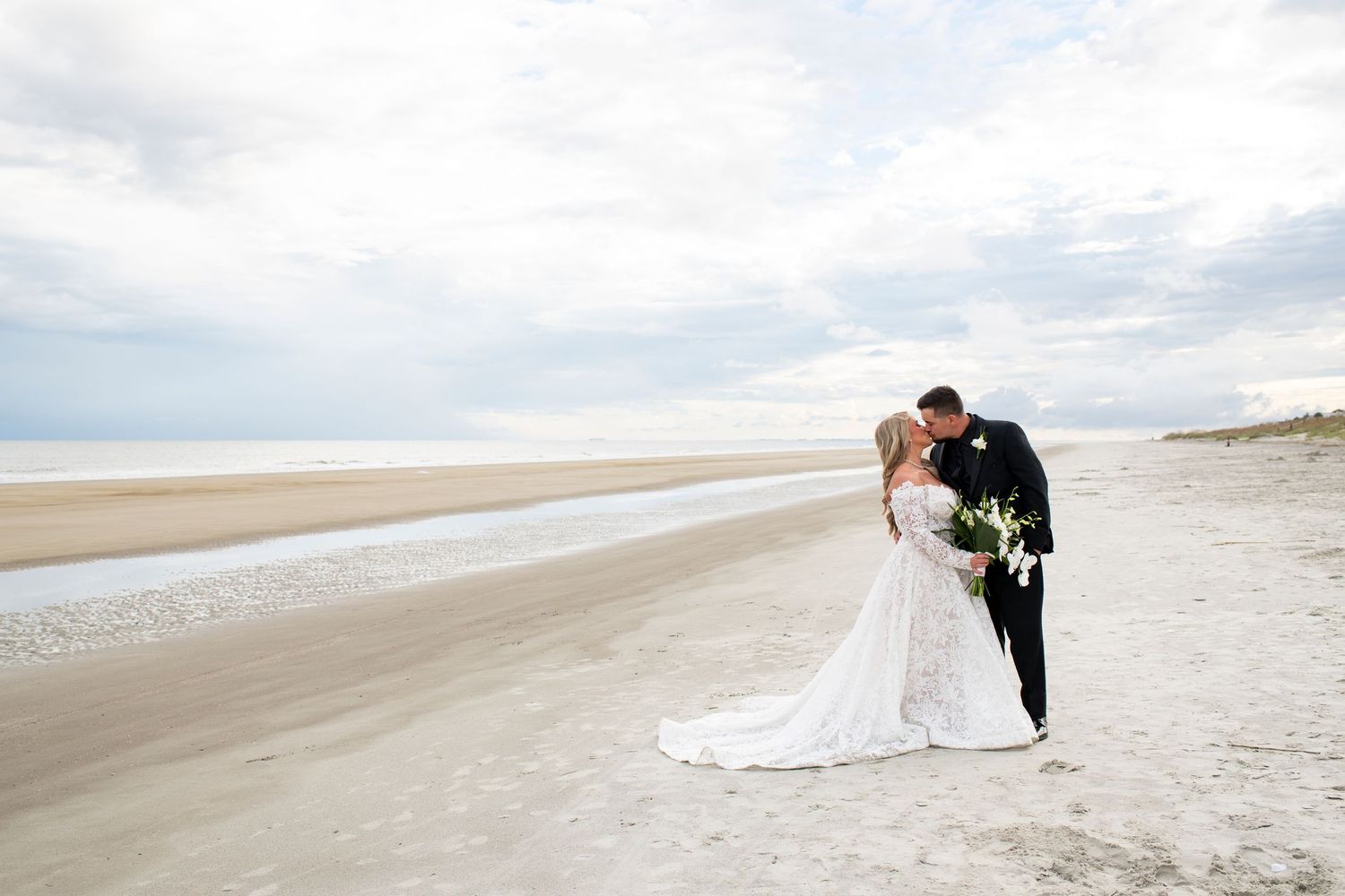Bride and groom kiss on their wedding day on the beach on Hilton Head Island in South Carolina.