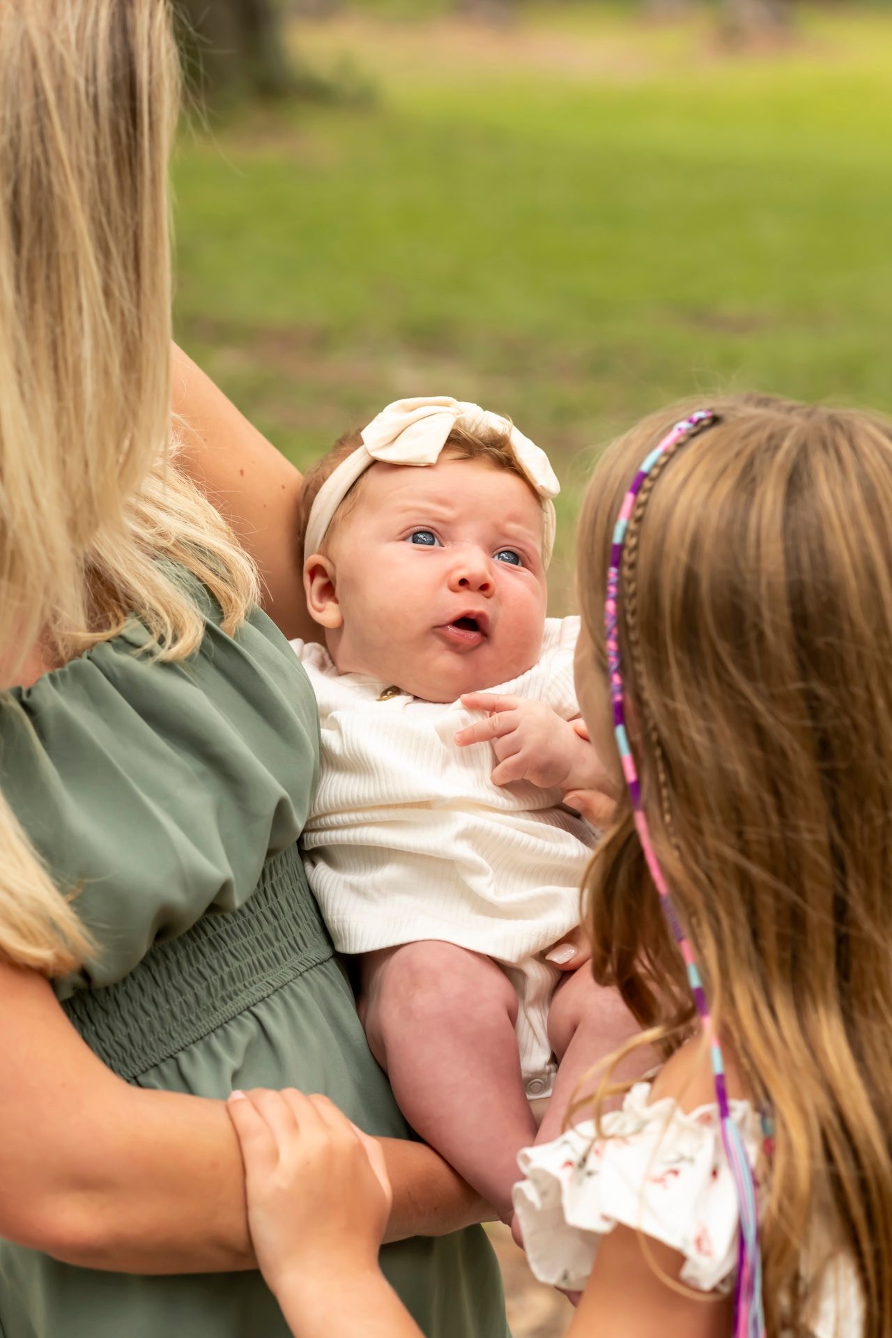 Close-up sequence showing tender family interaction and expressions on a sunny afternoon outdoors.
