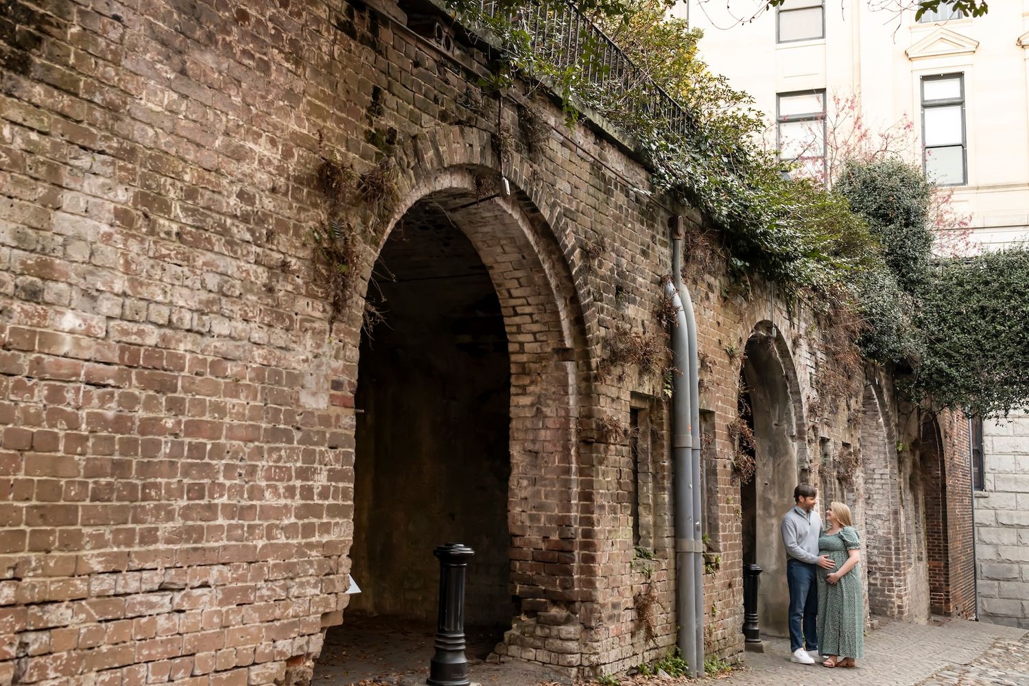 Historic stone archway passage with weathered brick walls and walkway leading through a building interior.