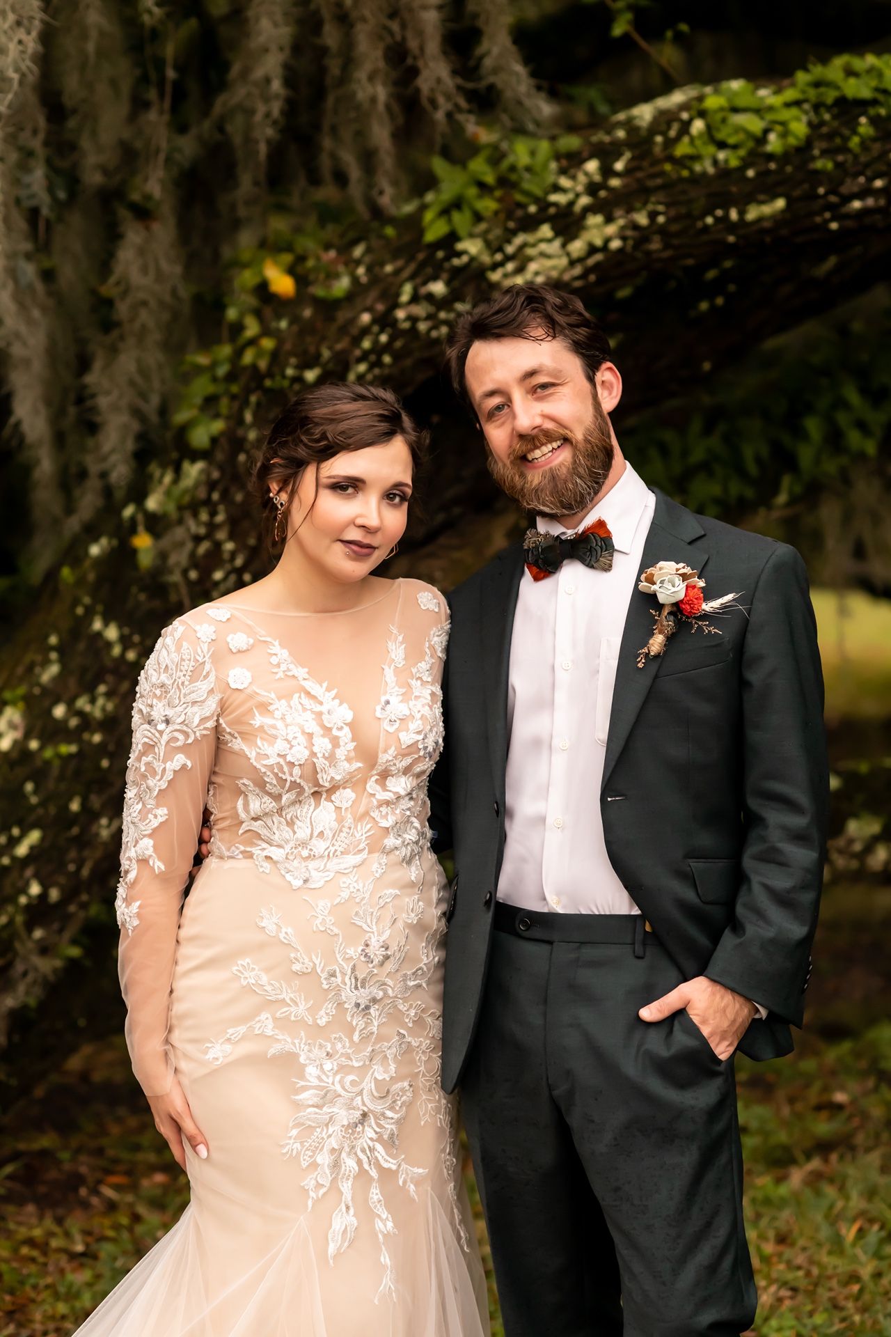 Wedding couple poses together at a romantic outdoor garden ceremony in elegant formal attire.