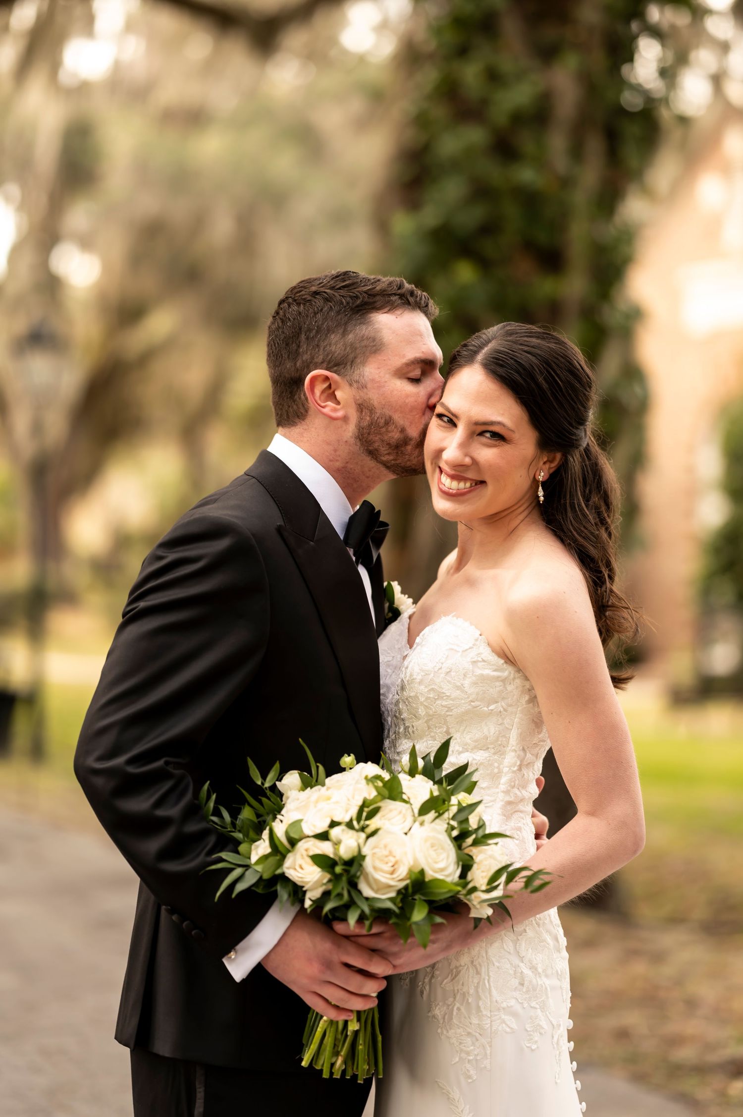 Romantic wedding portrait series of a newlywed couple sharing intimate moments together in a garden setting.