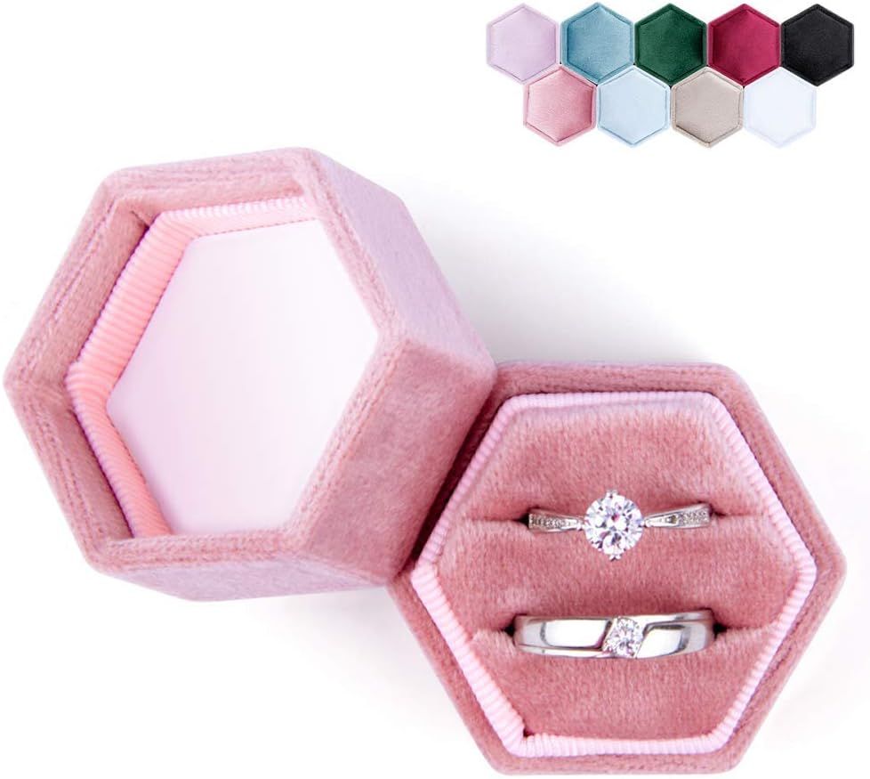 Pink hexagonal velvet ring box with engagement ring and wedding band displayed on plush interior, color swatches shown above.