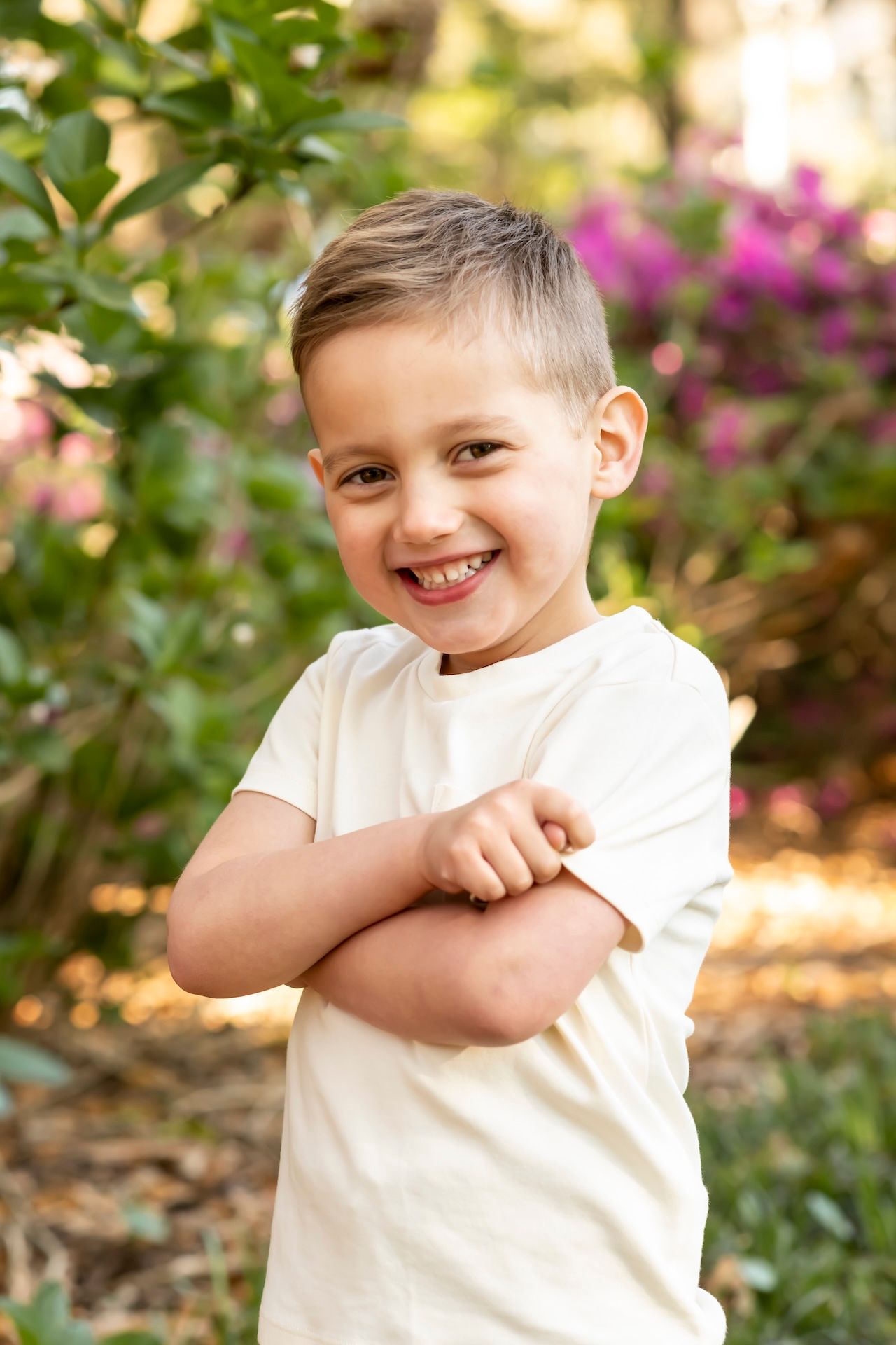 Playful expressions captured in sequence against a sunny garden backdrop with pink flowering bushes.