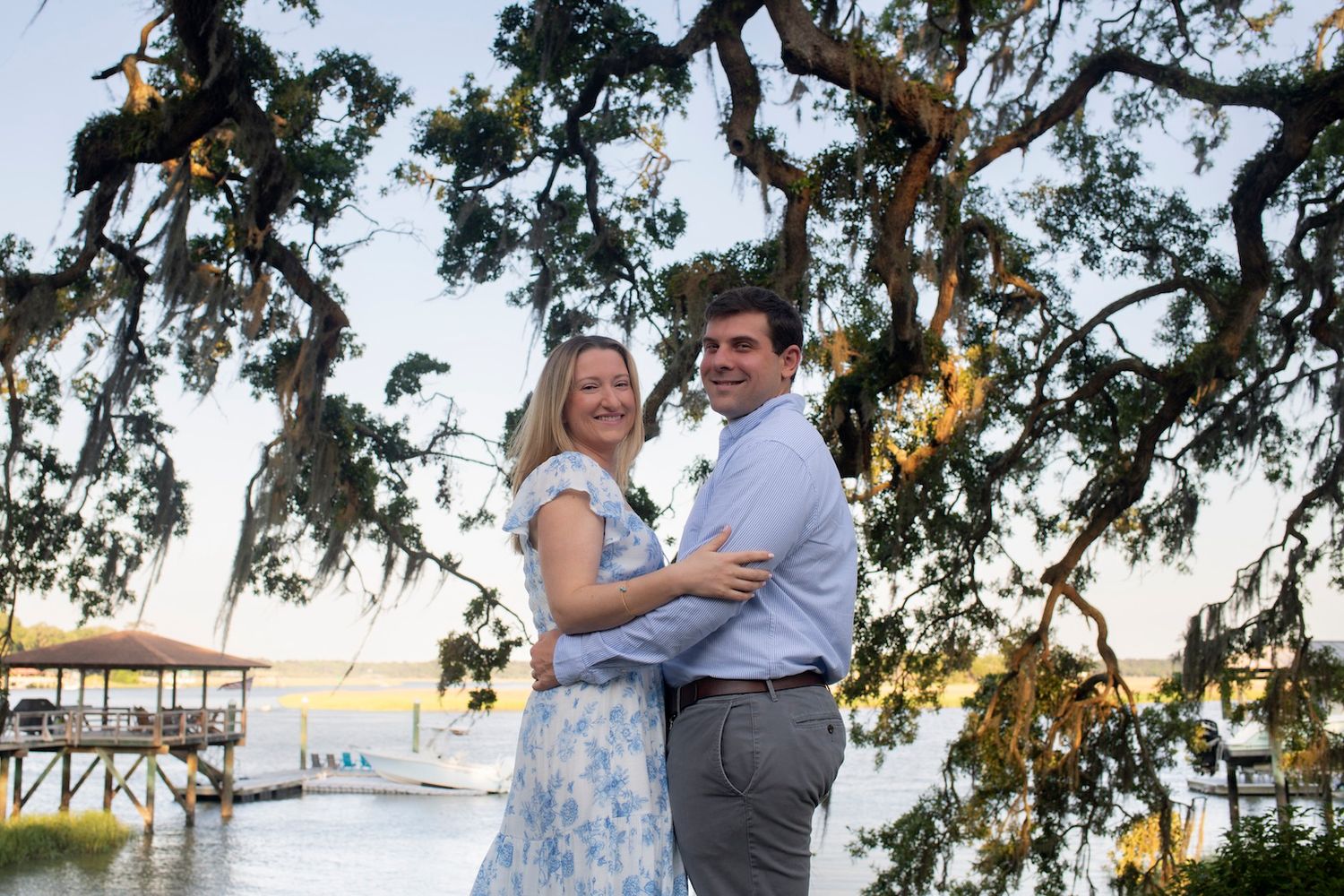 Couple shares romantic moments during sunset engagement photo session under Spanish moss draped oak trees.