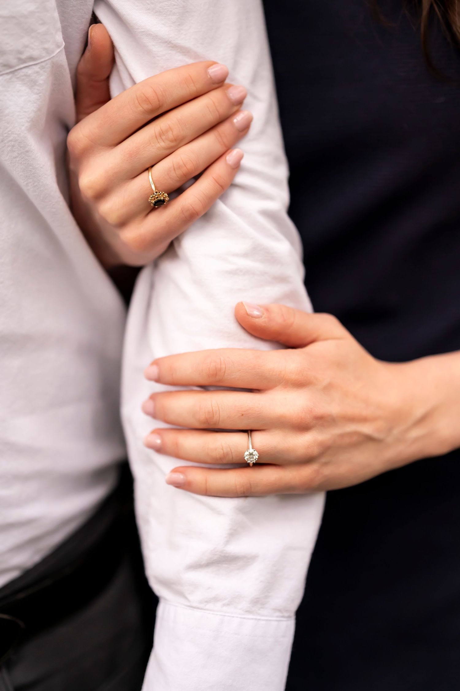 Close-up photos showing hands with wedding rings interlocked in five different embracing positions against black and white.