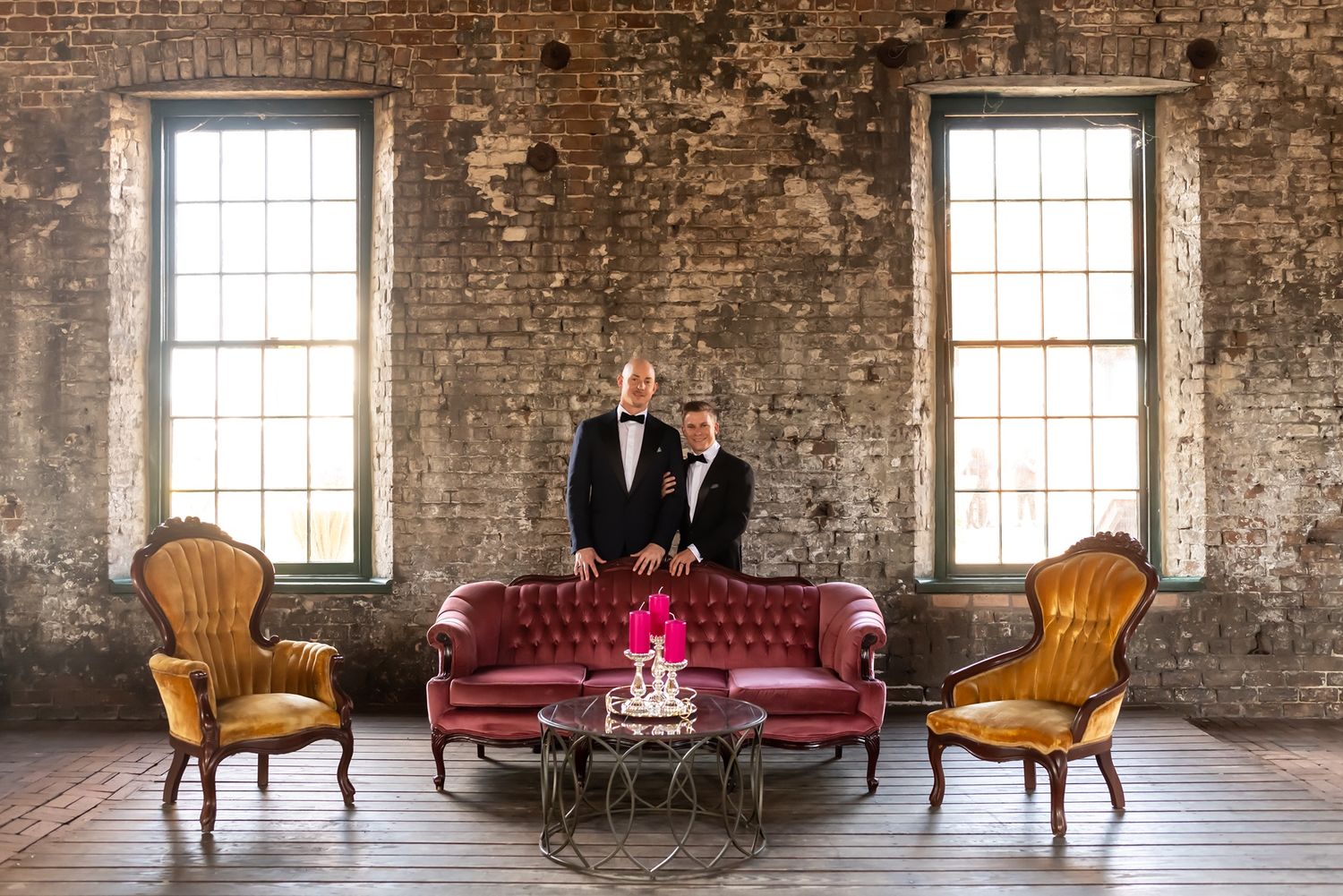 Elegant wedding venue with exposed brick walls and vintage wooden chairs arranged for a ceremony.