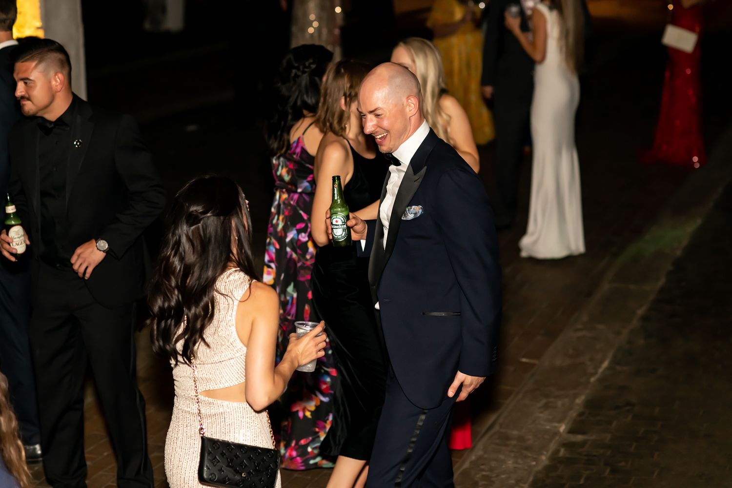 People enjoying themselves at an evening party or reception event with formal attire.