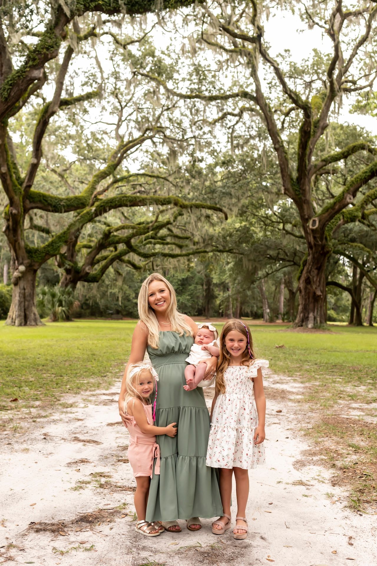 Candid family moments captured under Spanish moss trees in a park setting with natural lighting.