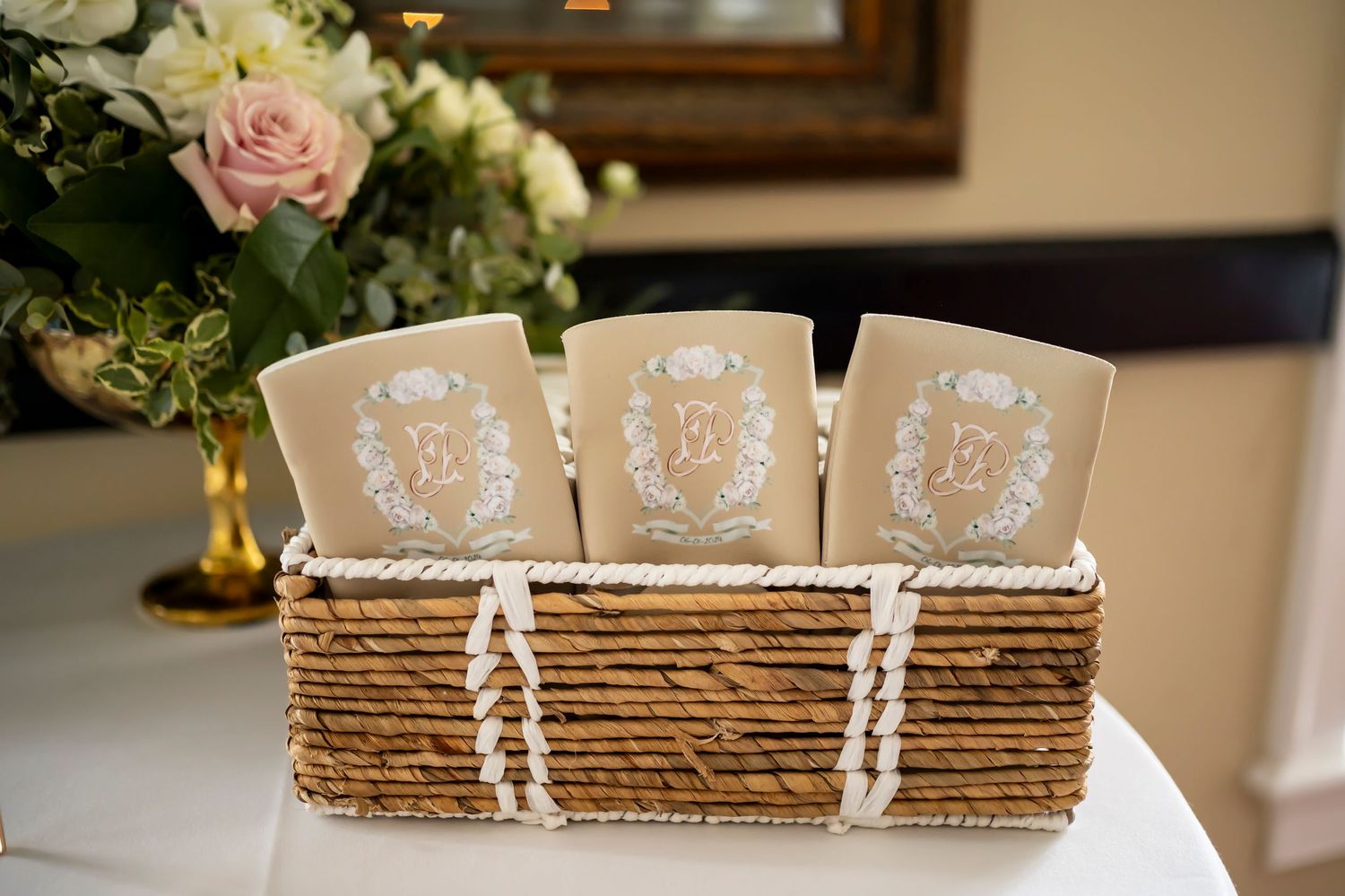 Rustic wedding decor featuring rope-wrapped photo albums and delicate blush roses on a wooden surface.