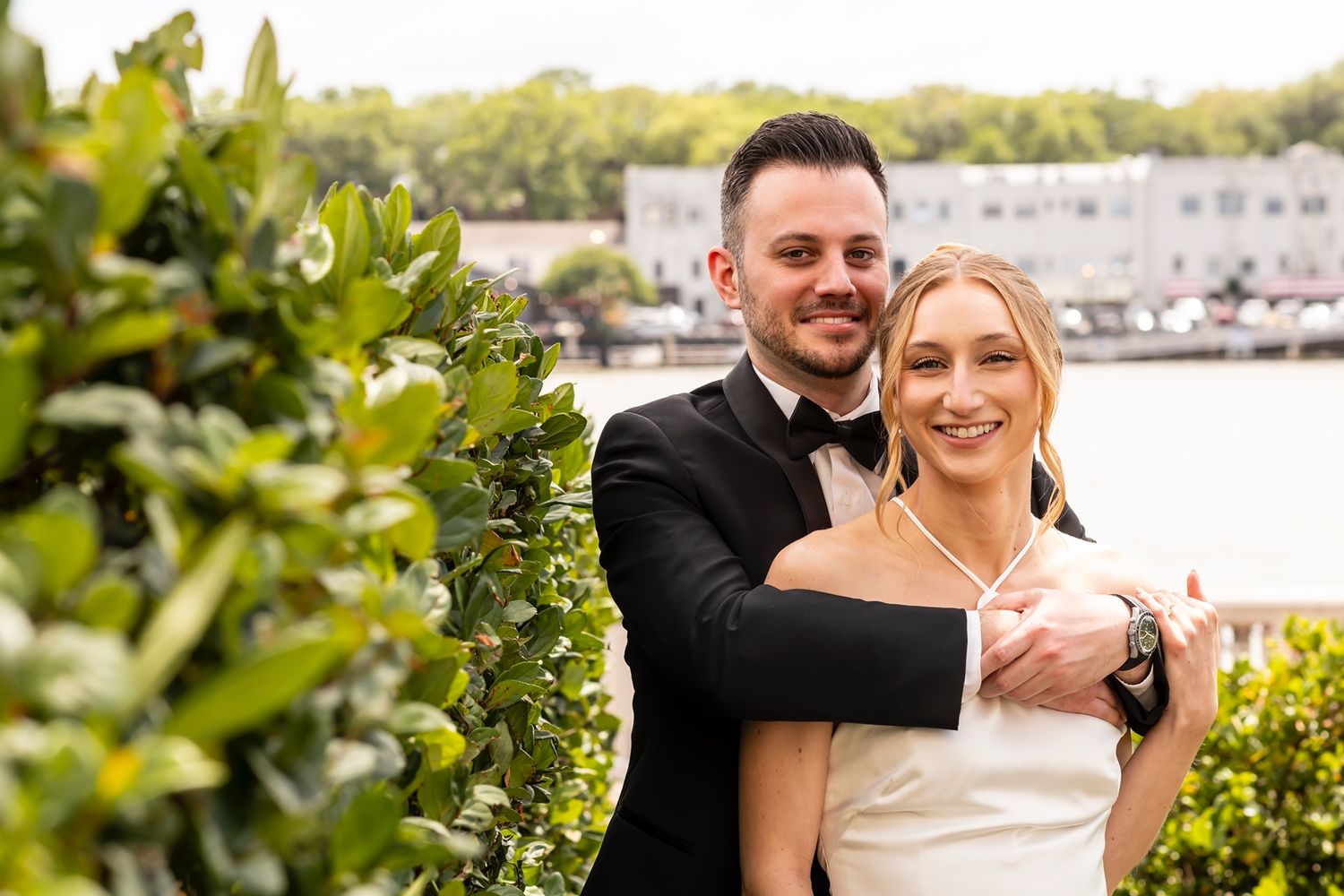Wedding couple shares joyful moments together in a lush garden setting with tropical greenery.