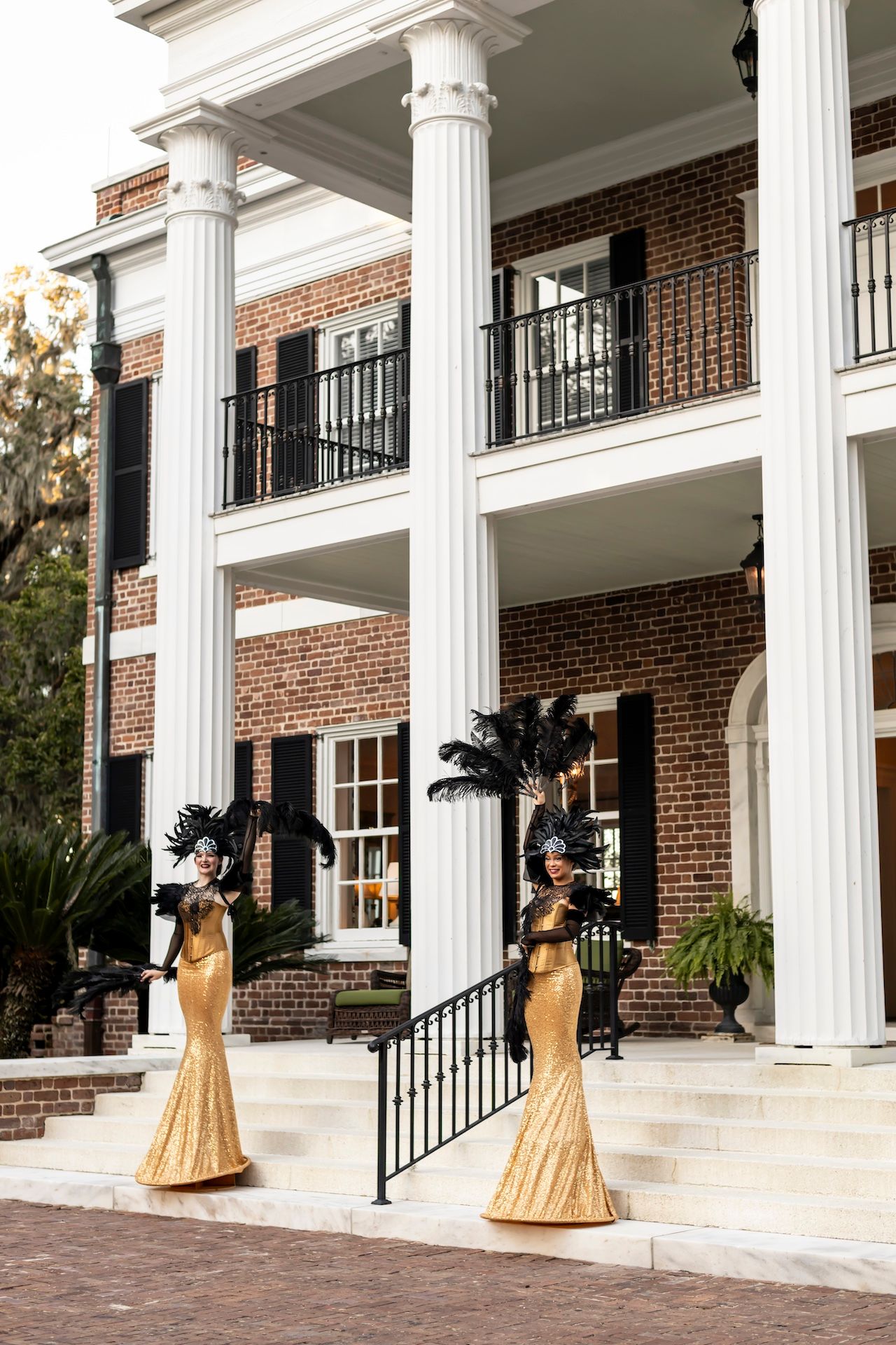 A person in a yellow antebellum-style dress walks across a white-columned brick building's veranda in multiple photo angles.