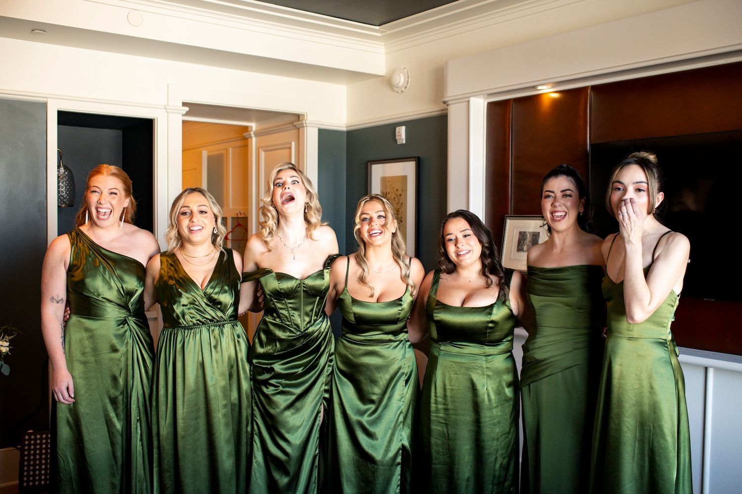 Bridesmaids wearing matching emerald green satin dresses pose together in a fun photo sequence.