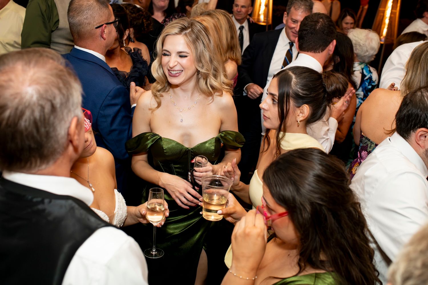 Wedding guests dancing and mingling on a crowded dance floor at an elegant evening reception.