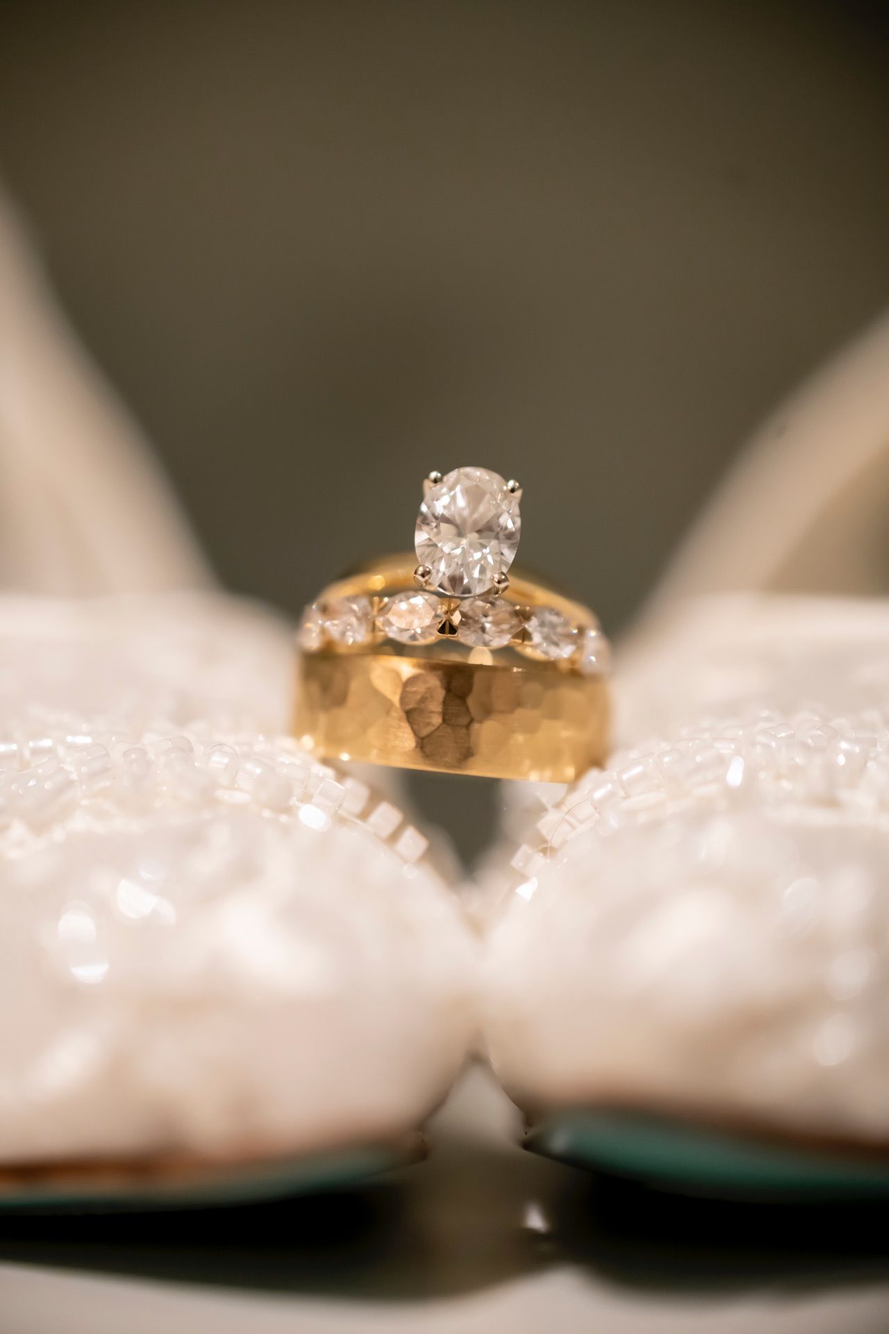 A series of close-up macro shots showcasing a beautiful engagement ring with diamonds against a white textured surface.