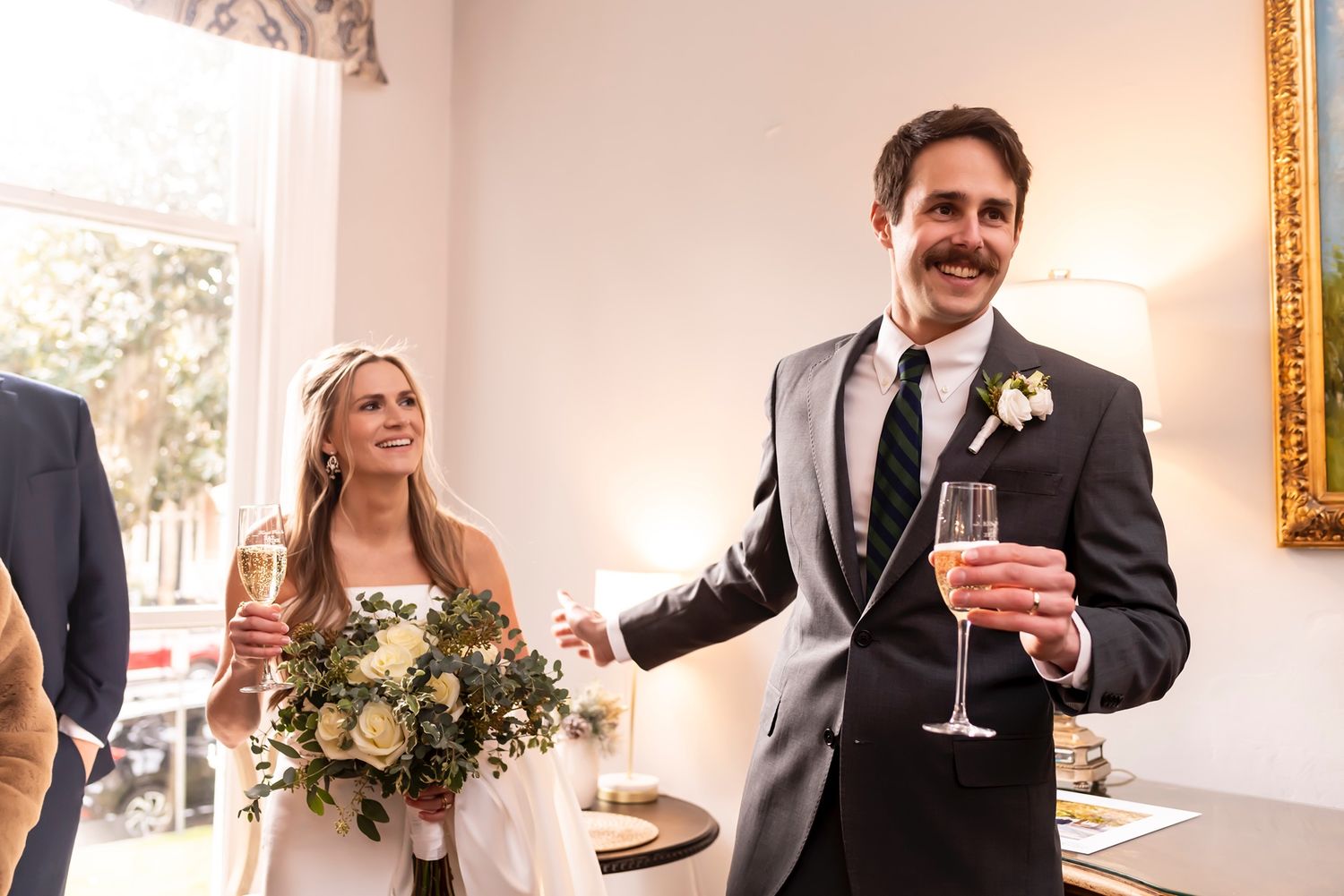 Wedding guests enjoy drinks and conversation during an elegant indoor reception at a historic venue.