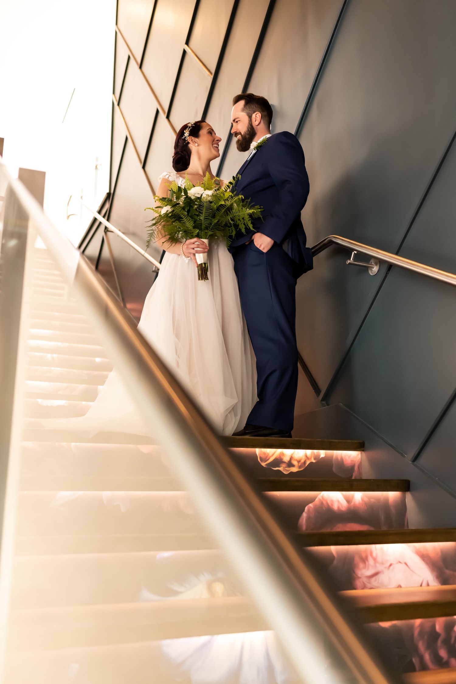 A bride and groom on staircase at their Thompson Savannah wedding.