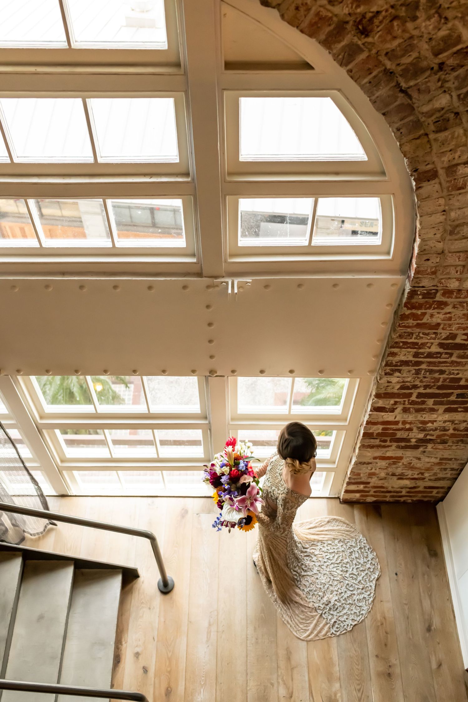 Bride looking out window to River Street at the JW Marriott Plant Riverside in Savannah, Georgia.