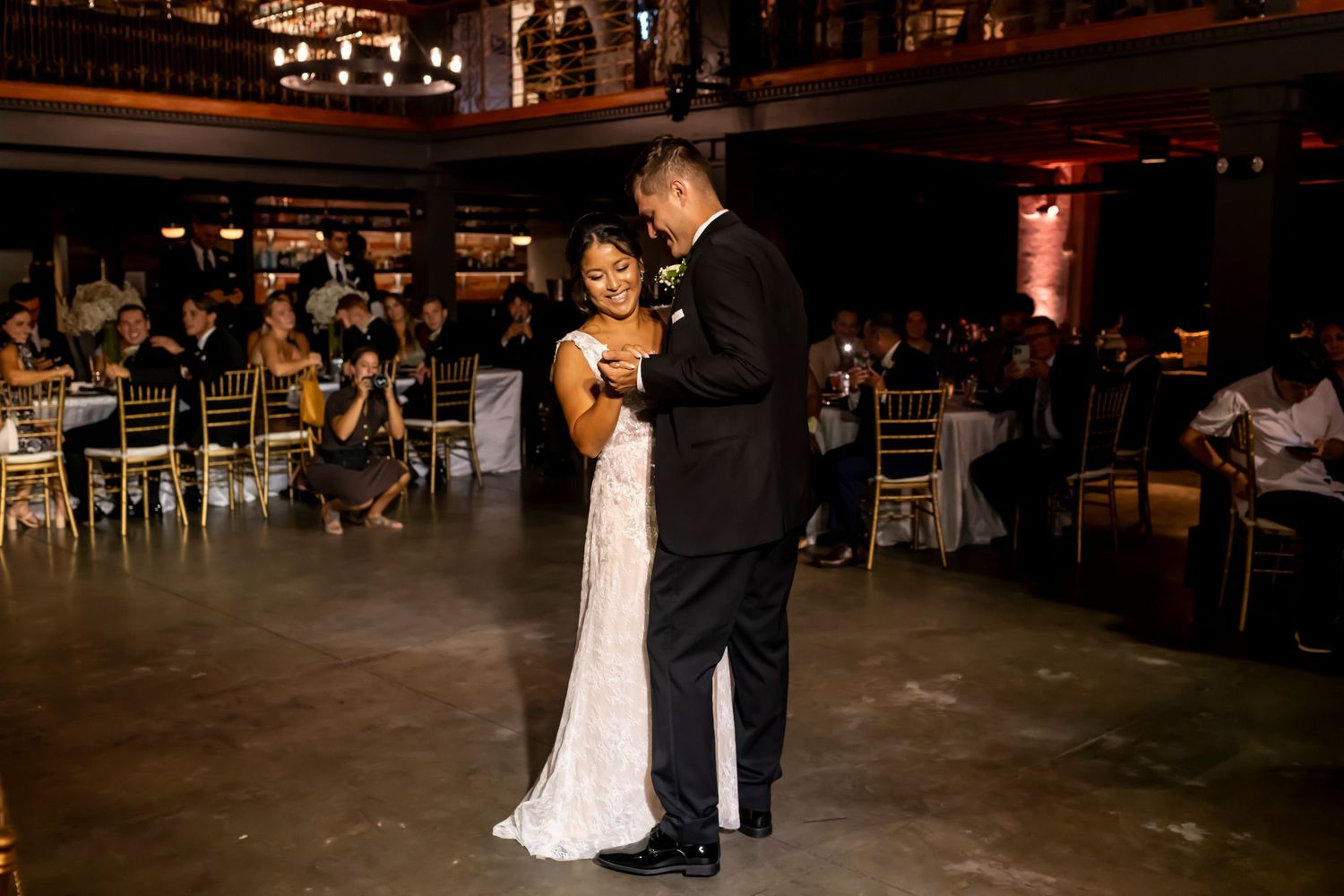 Wedding reception dance floor with ambient lighting and guests celebrating.
