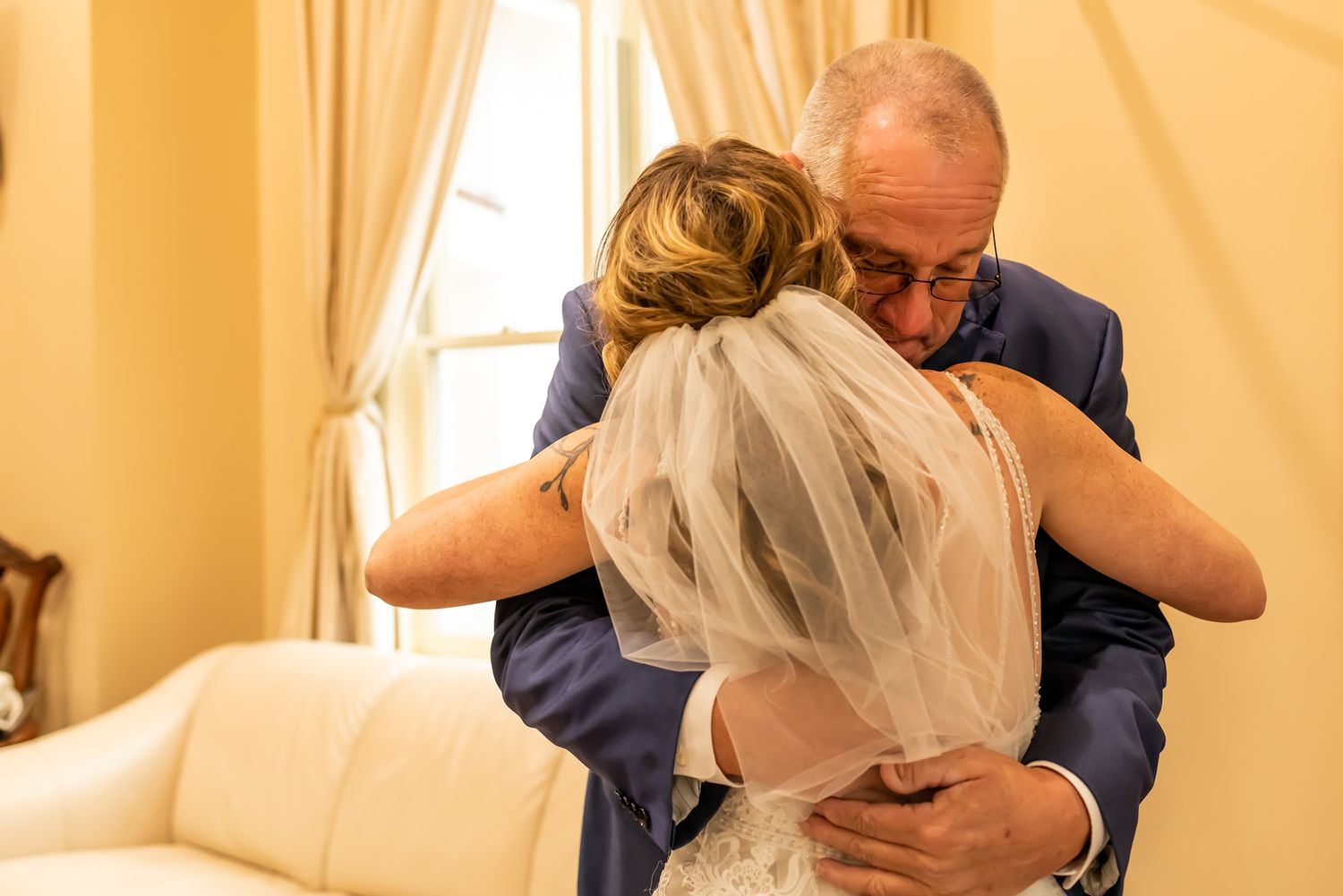 A collection of emotional moments during a wedding with hugs and embraces in a light-filled venue.