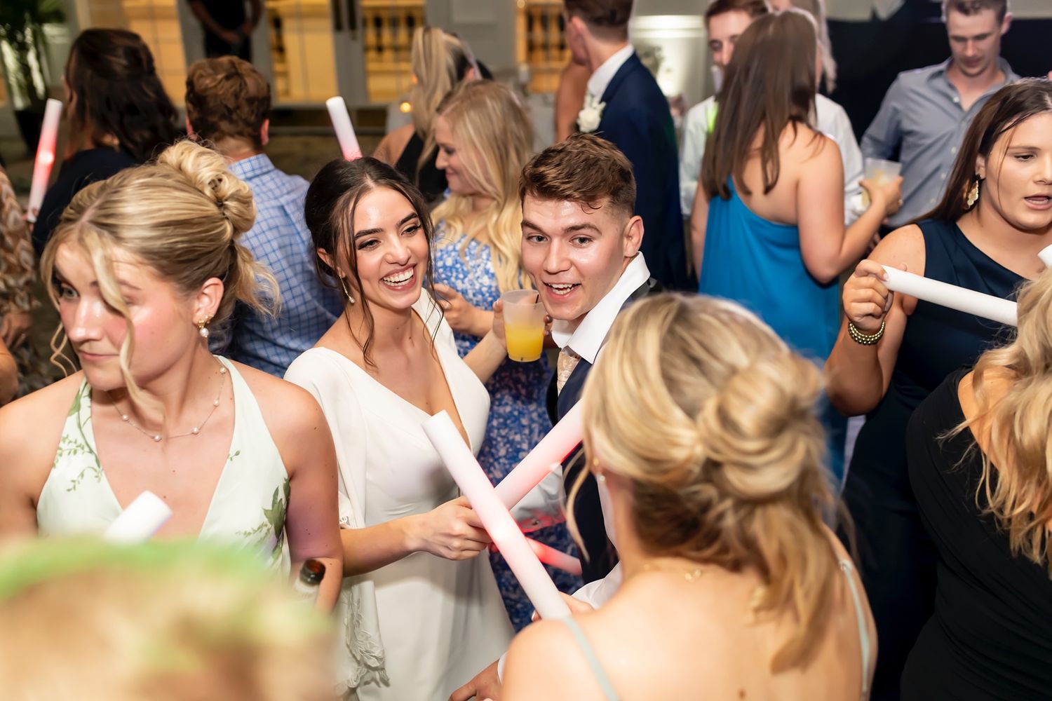 Wedding guests share joyful laughter and conversation during a lively reception celebration.