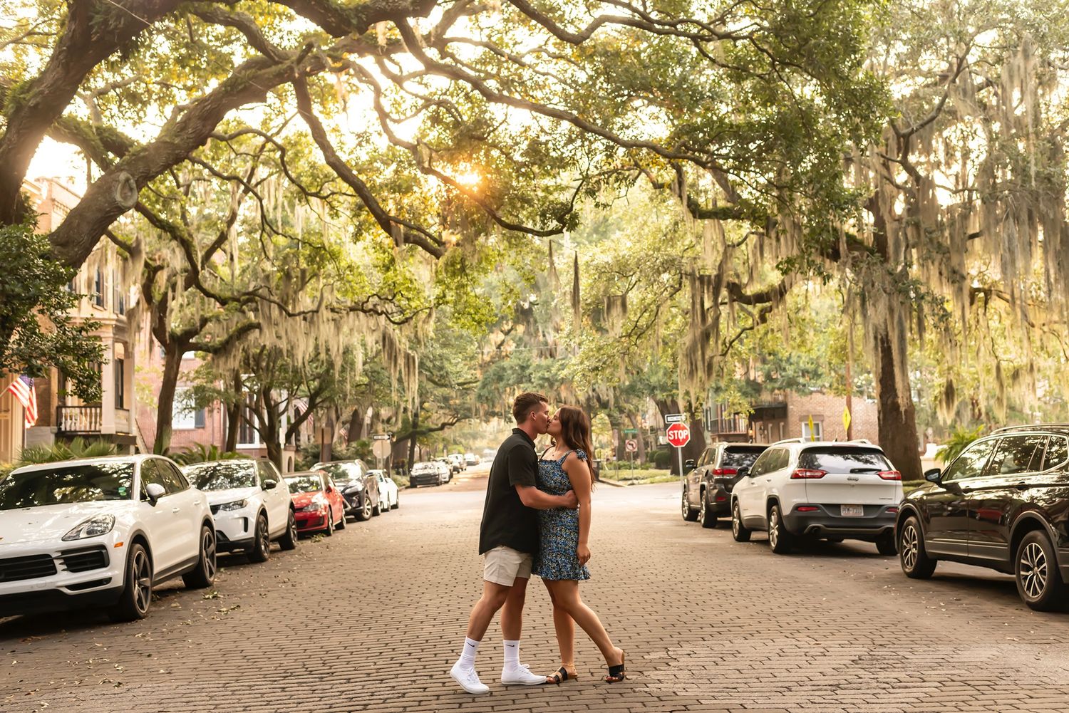 Romantic street scene under moss-draped oak trees in historic Savannah, Georgia at golden hour.