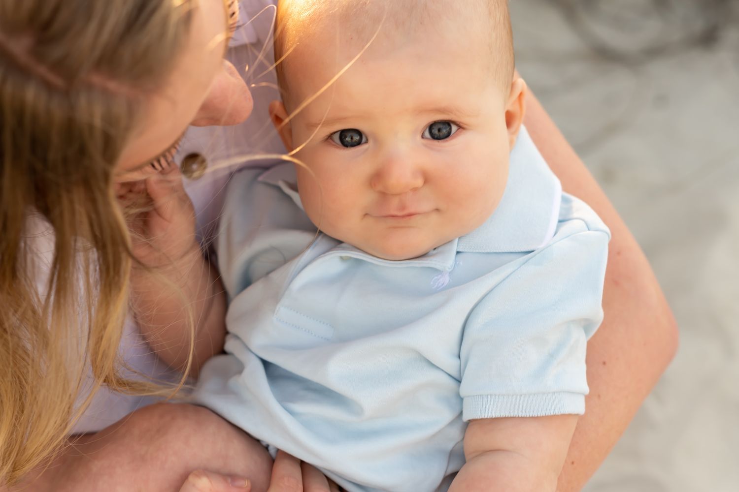 A tender parenting moment captured during a feeding session with a baby in a light blue outfit.
