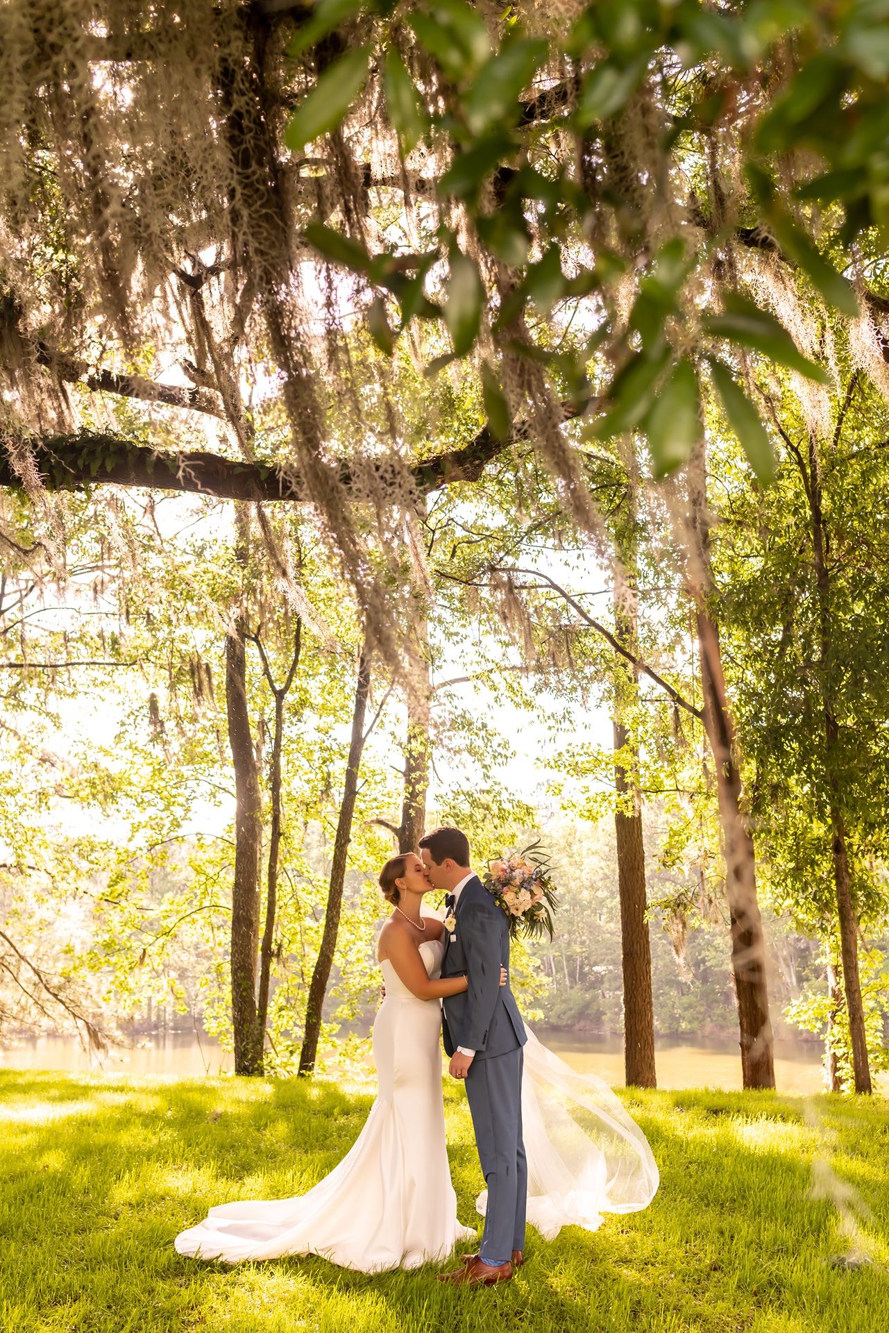 A romantic scene unfolds in a sun-drenched forest with Spanish moss hanging from the trees created dreamy lighting.