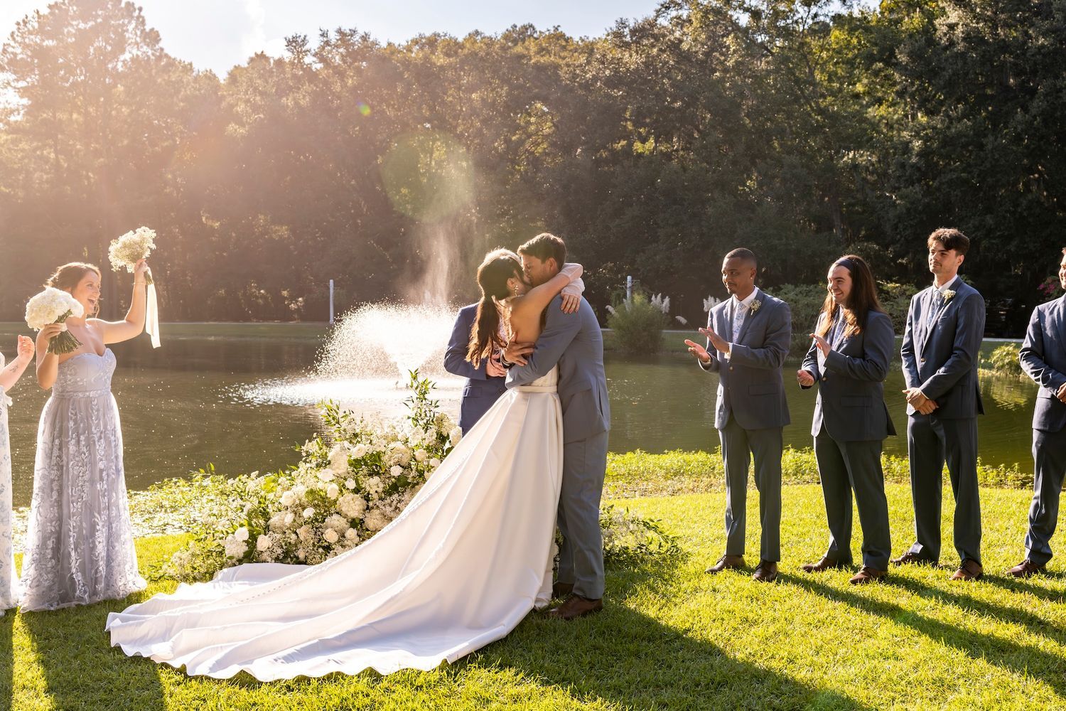 Wedding couple shares a tender moment during golden hour photography session in a sun-drenched garden setting.