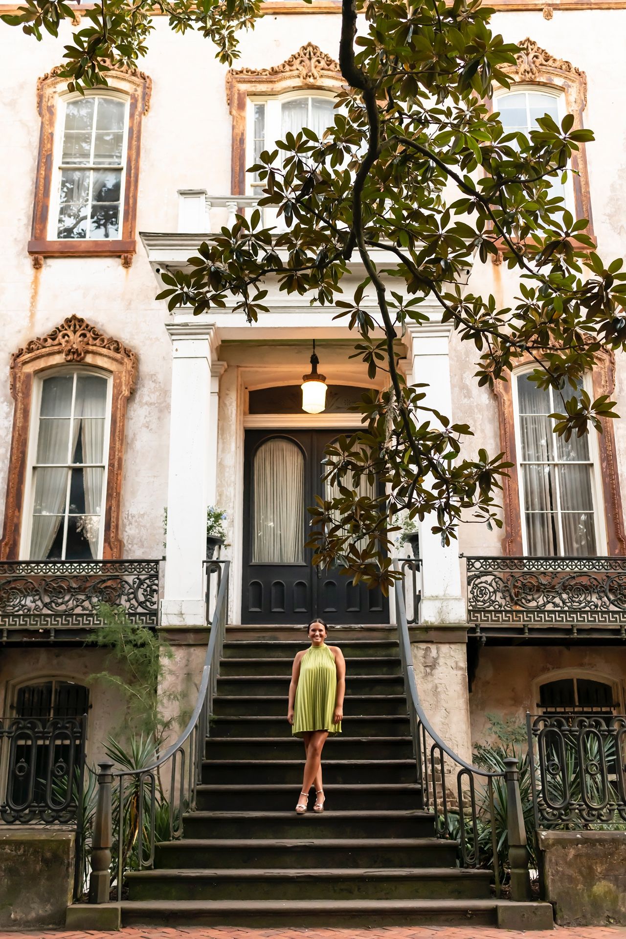 Row of ornate Victorian brownstone buildings with decorative wrought iron railings and staircases in an urban setting.