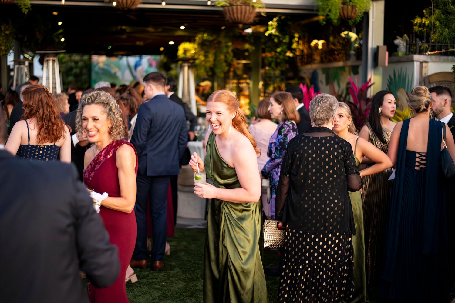 Wedding guests dance together during an evening reception celebration on the dance floor.