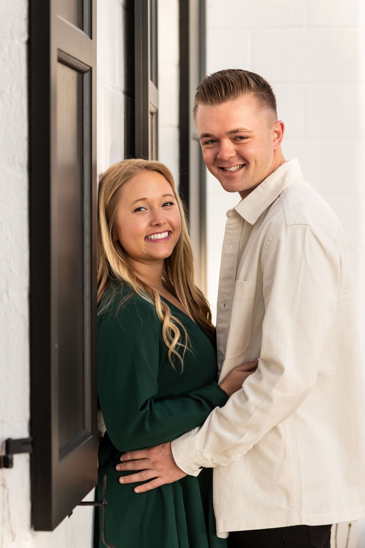 Three photos of a couple in green and white outfits posing against a white wall with black frames.