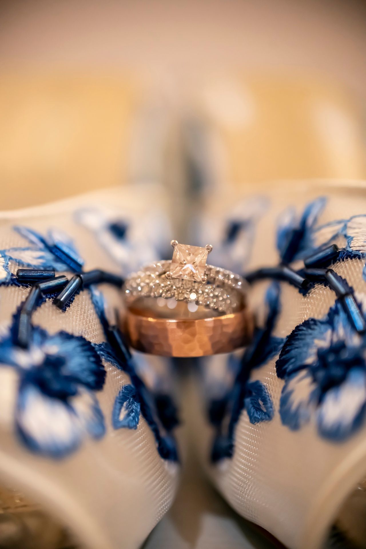 Close-up of diamond engagement ring on blue garter lace with bokeh effect.