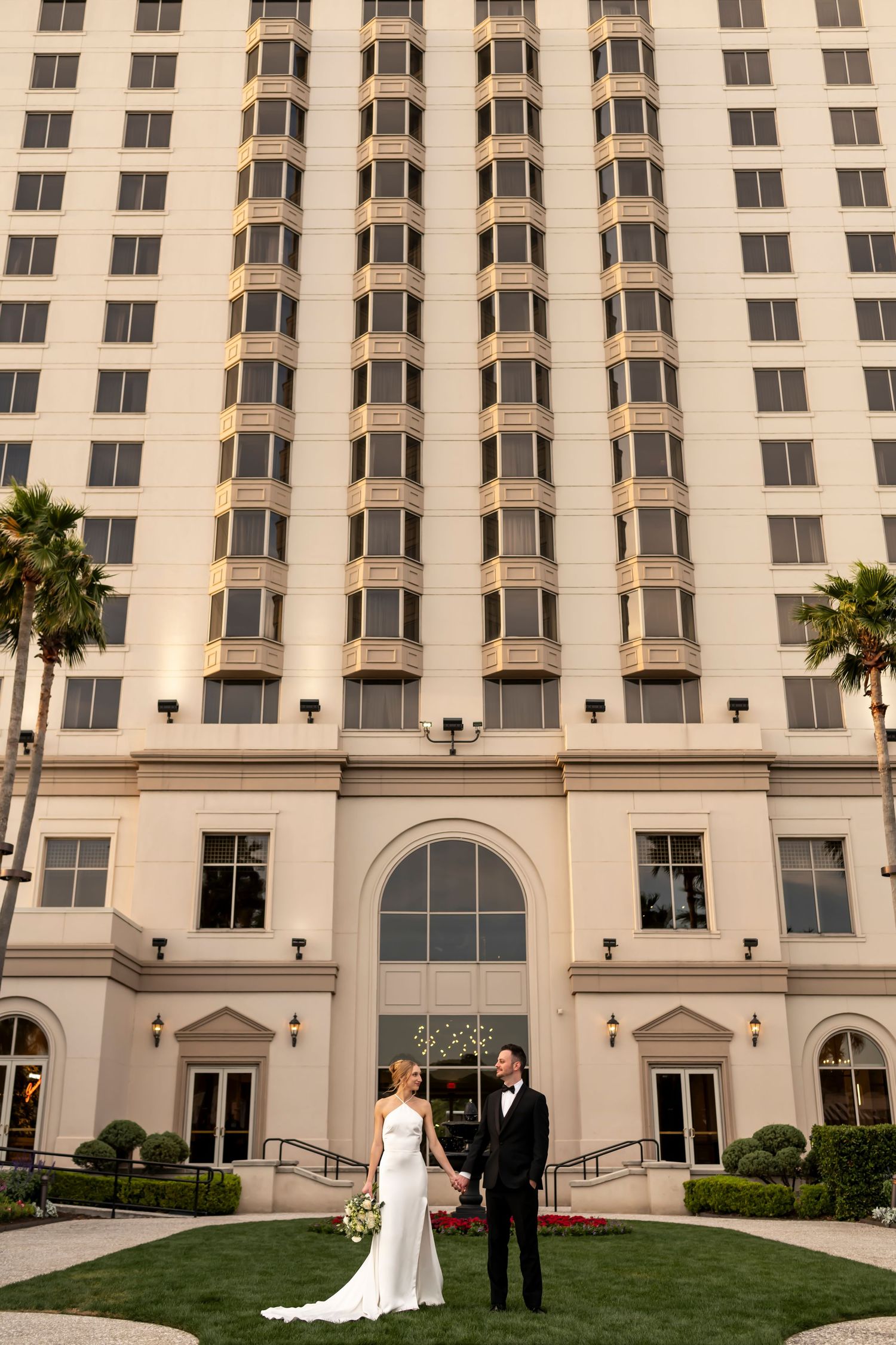 Bridal portraits in front of Savannah luxury hotel with elegant columns and palm trees.