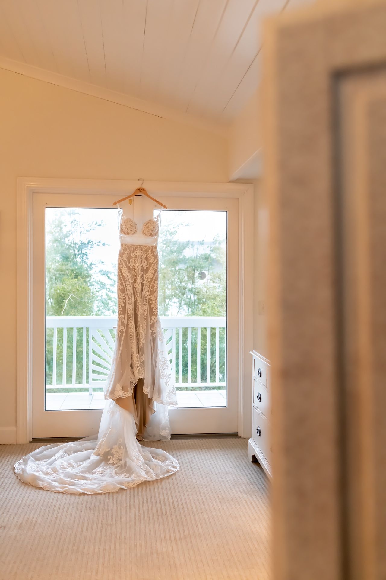 Wedding dress photographed in sunlit room with white walls, windows, and carpeting showing different views and angles.