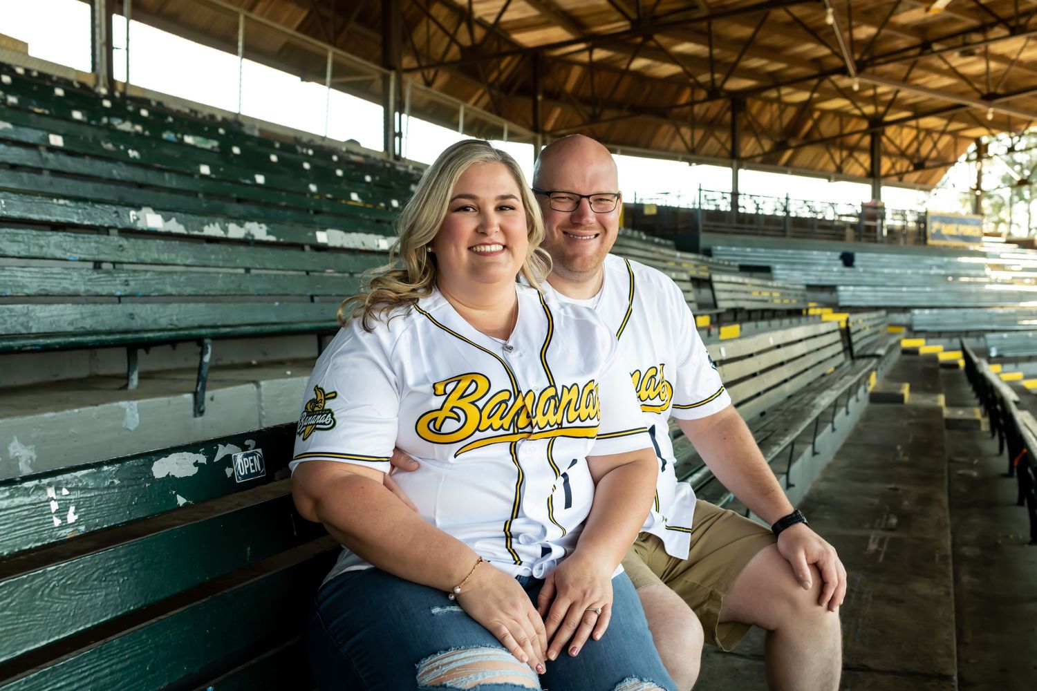 Engaged couple wearing Savannah Bananas jerseys for their engagement session at Grayson Stadium.