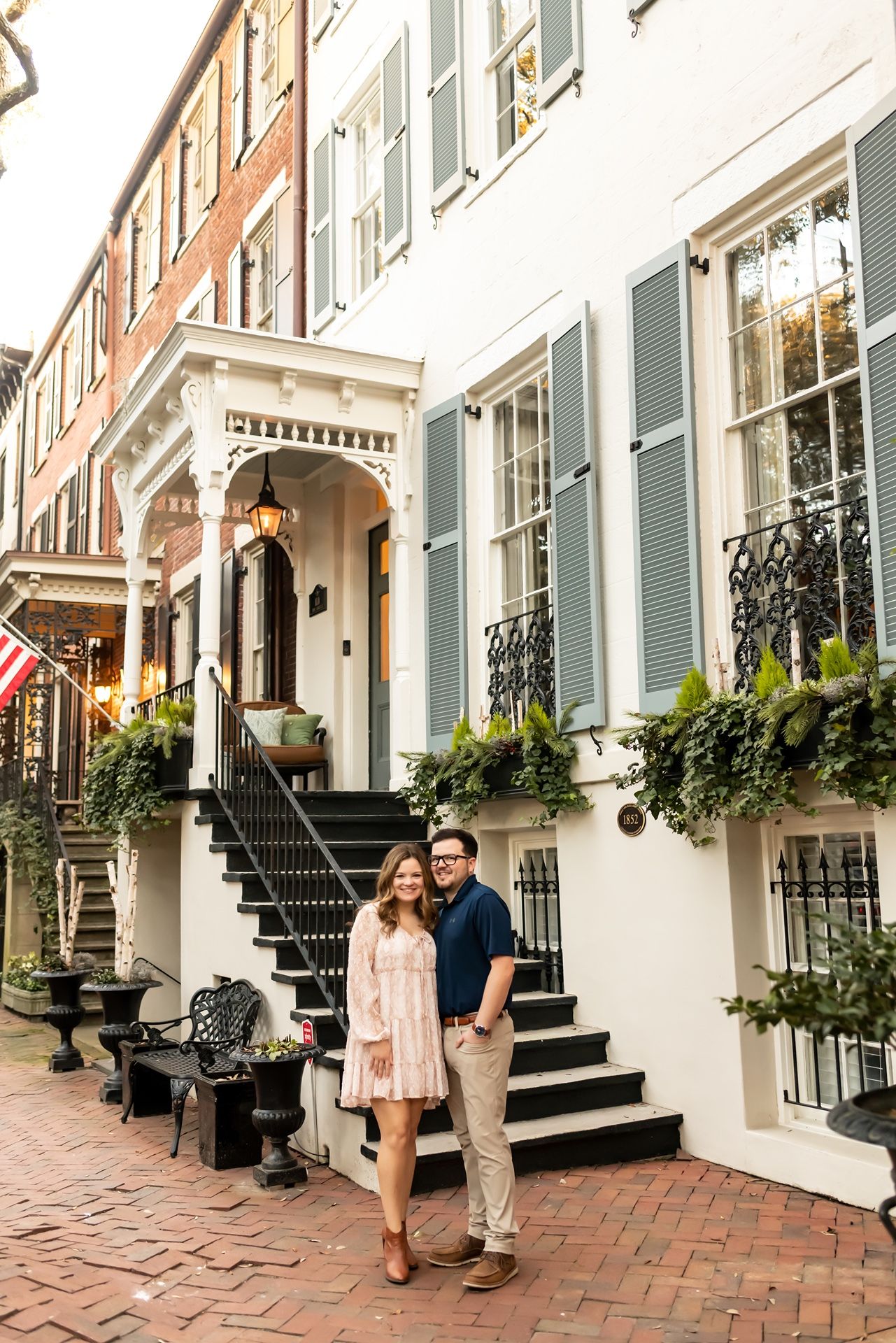 Historic brownstone exterior with brick steps leading to ornate entrance archway, decorative railings and window boxes in Charleston.