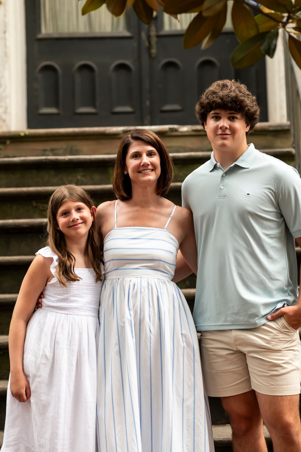Four sequential poses of two people wearing white summer outfits standing together on outdoor steps.