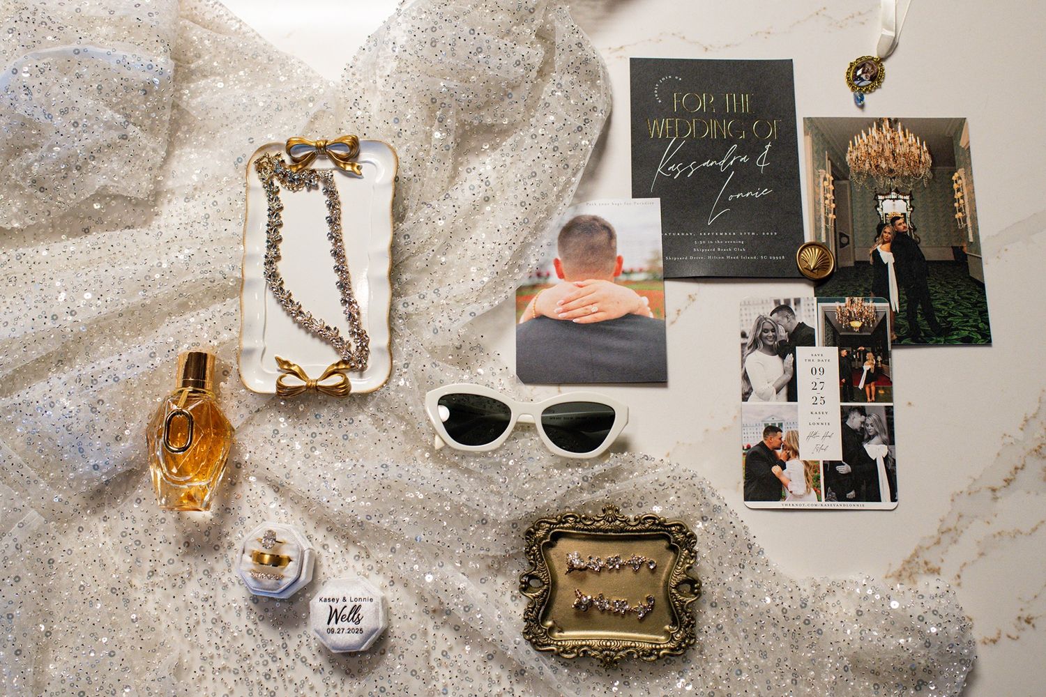 Flatlay of vintage perfume bottles, sunglasses, jewelry, and personal accessories arranged on a white textured surface.