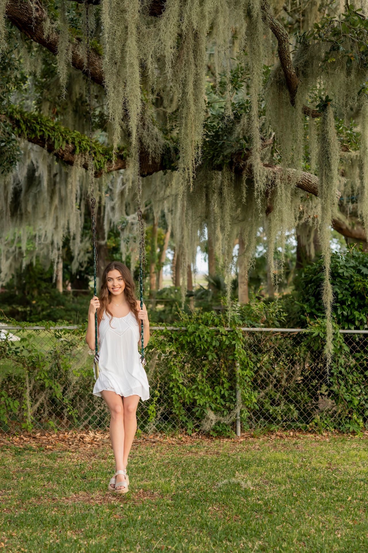 A senior portrait taken on a swing in a backyard in Savannah, Georgia.