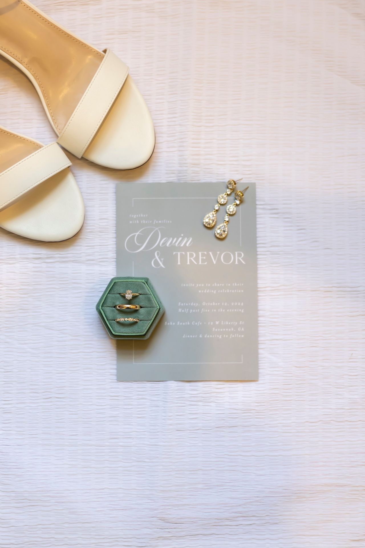 Modern wedding invitation details with elegant sage green hex disc, sheer vellum overlay, and gold metallic elements on white.