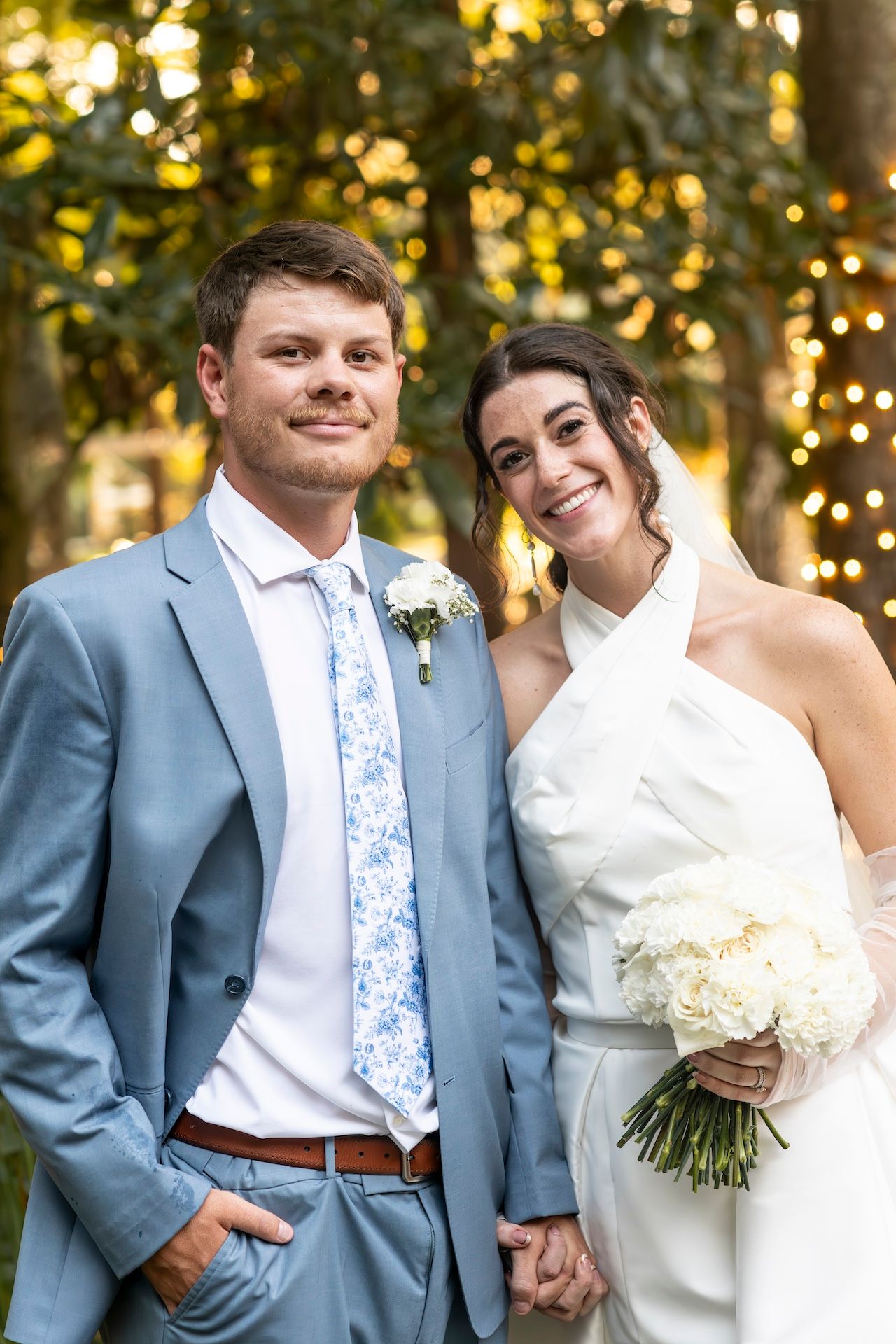 Series of five wedding portraits showing couple in blue suit and white dress posing against outdoor setting with bokeh lights.