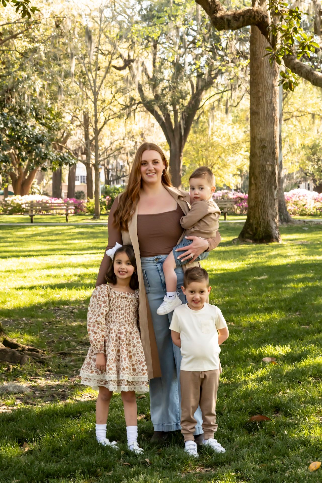 Family enjoying a sunny autumn day together in a park with trees and grass.