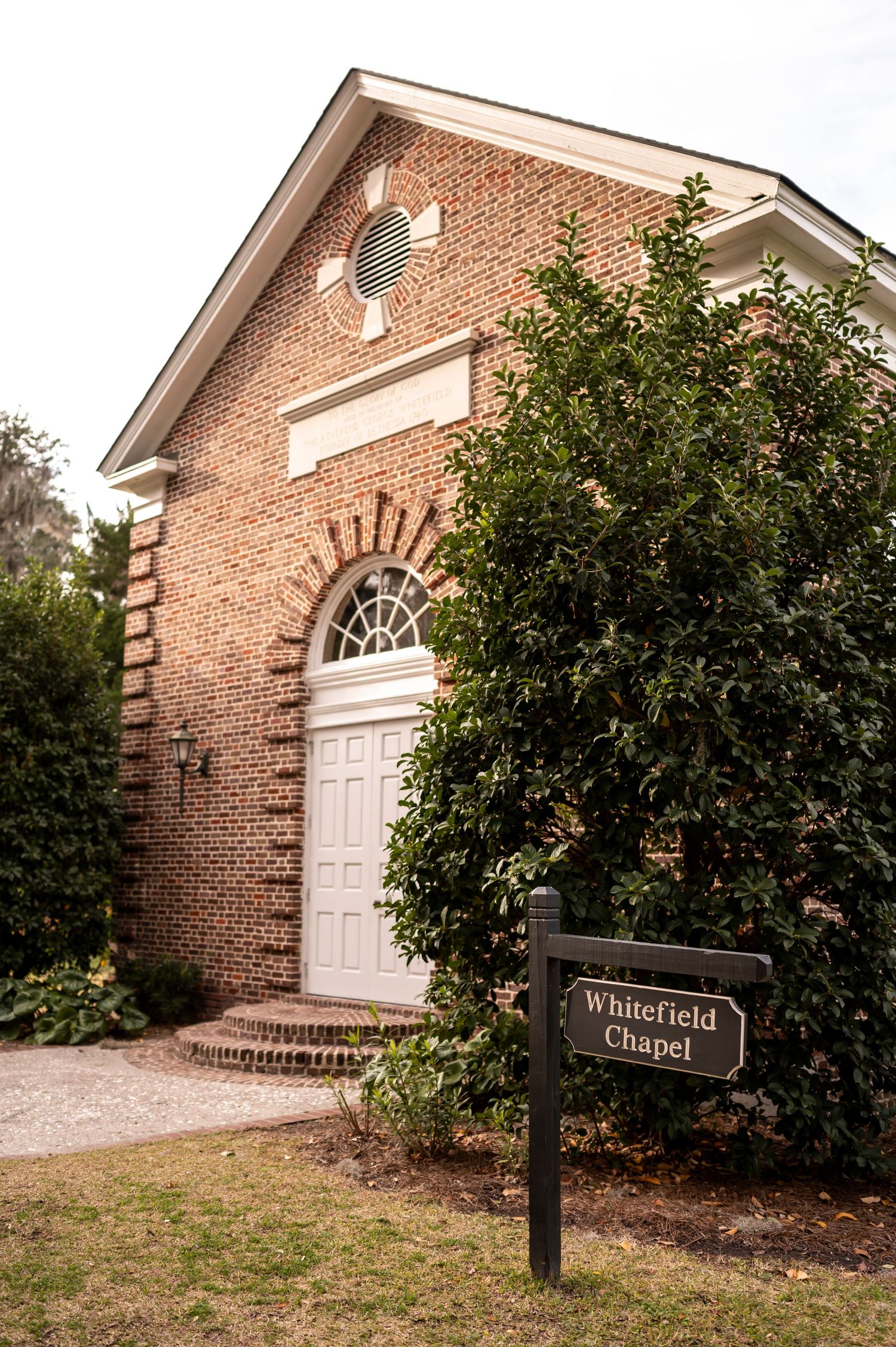 Series of brick chapel building exterior views showing white door, arched window and building name sign at Winterfield.