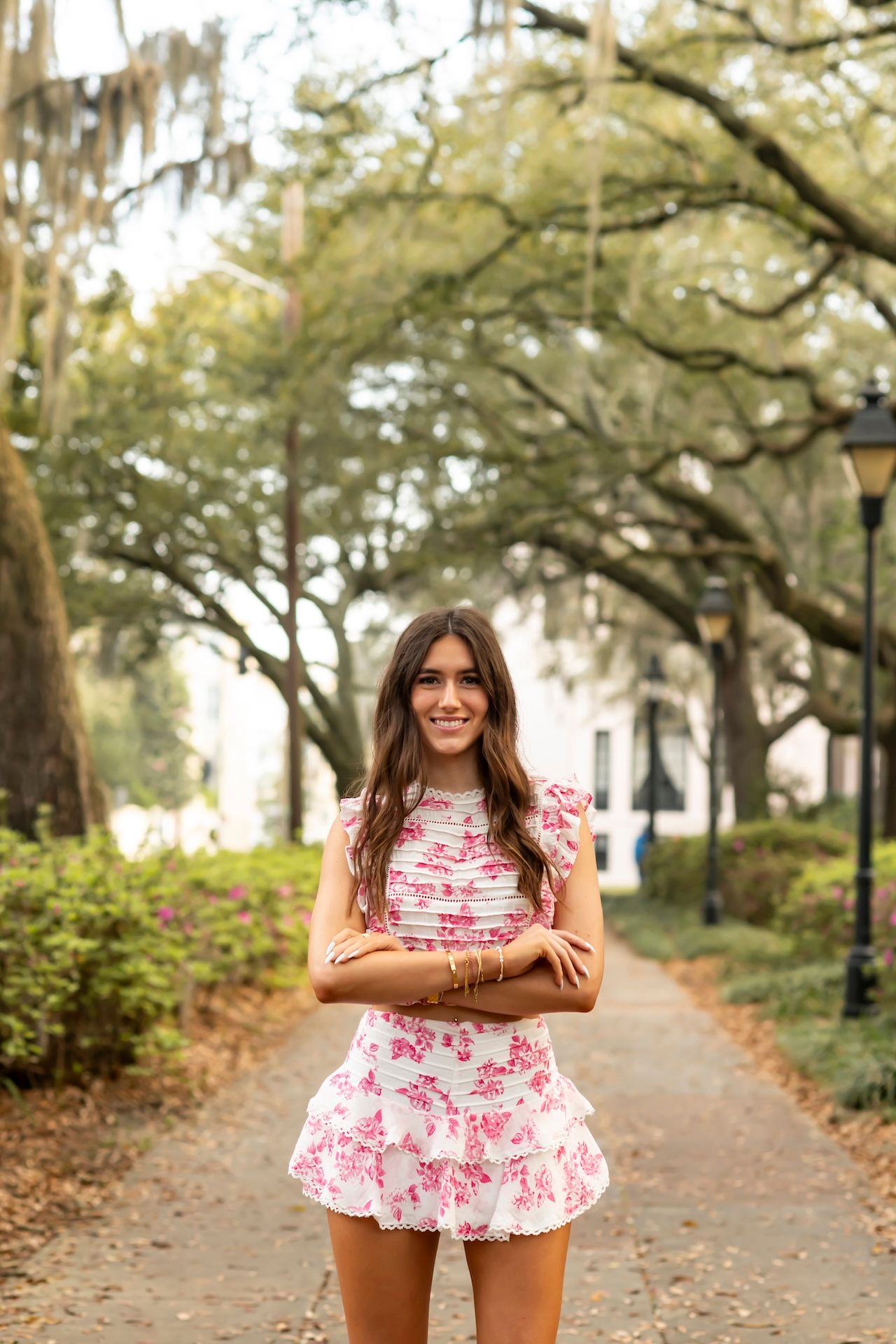 Pink floral two-piece ensemble photographed on a tree-lined pathway with Spanish moss overhead.