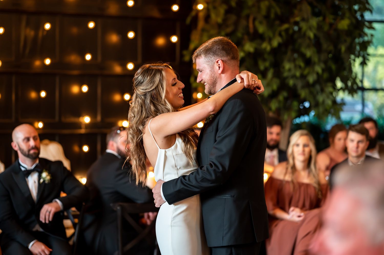 Couples dancing together at an indoor wedding reception with warm ambient lighting and festive atmosphere.